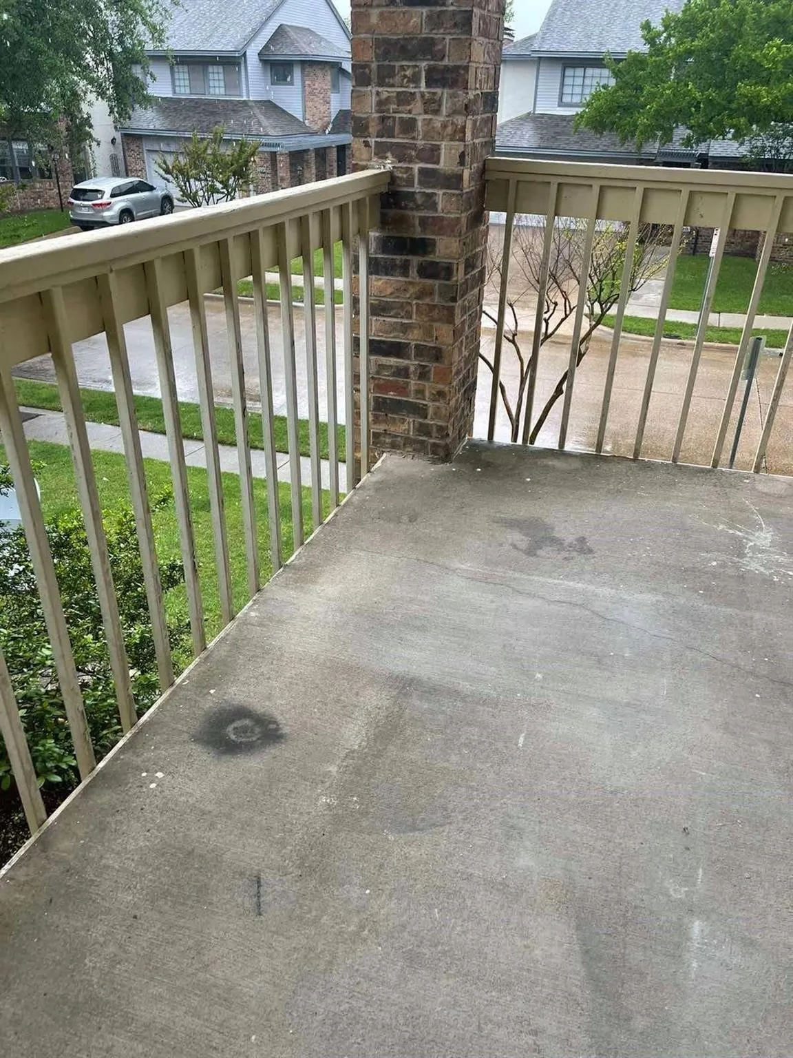 Concrete balcony with brick pillar and metal railings