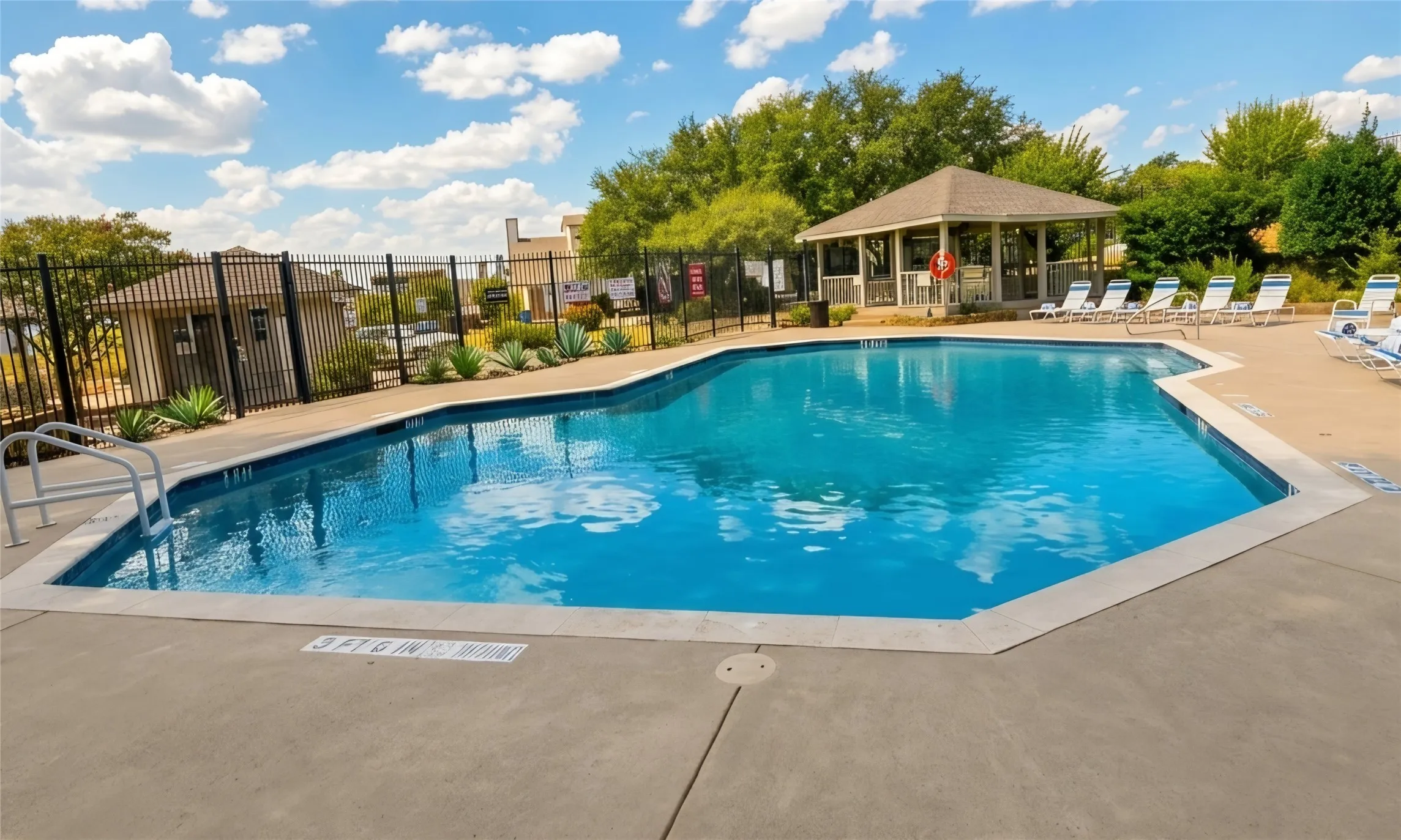 Community Swimming pool with security fencing, and a shaded pavilion