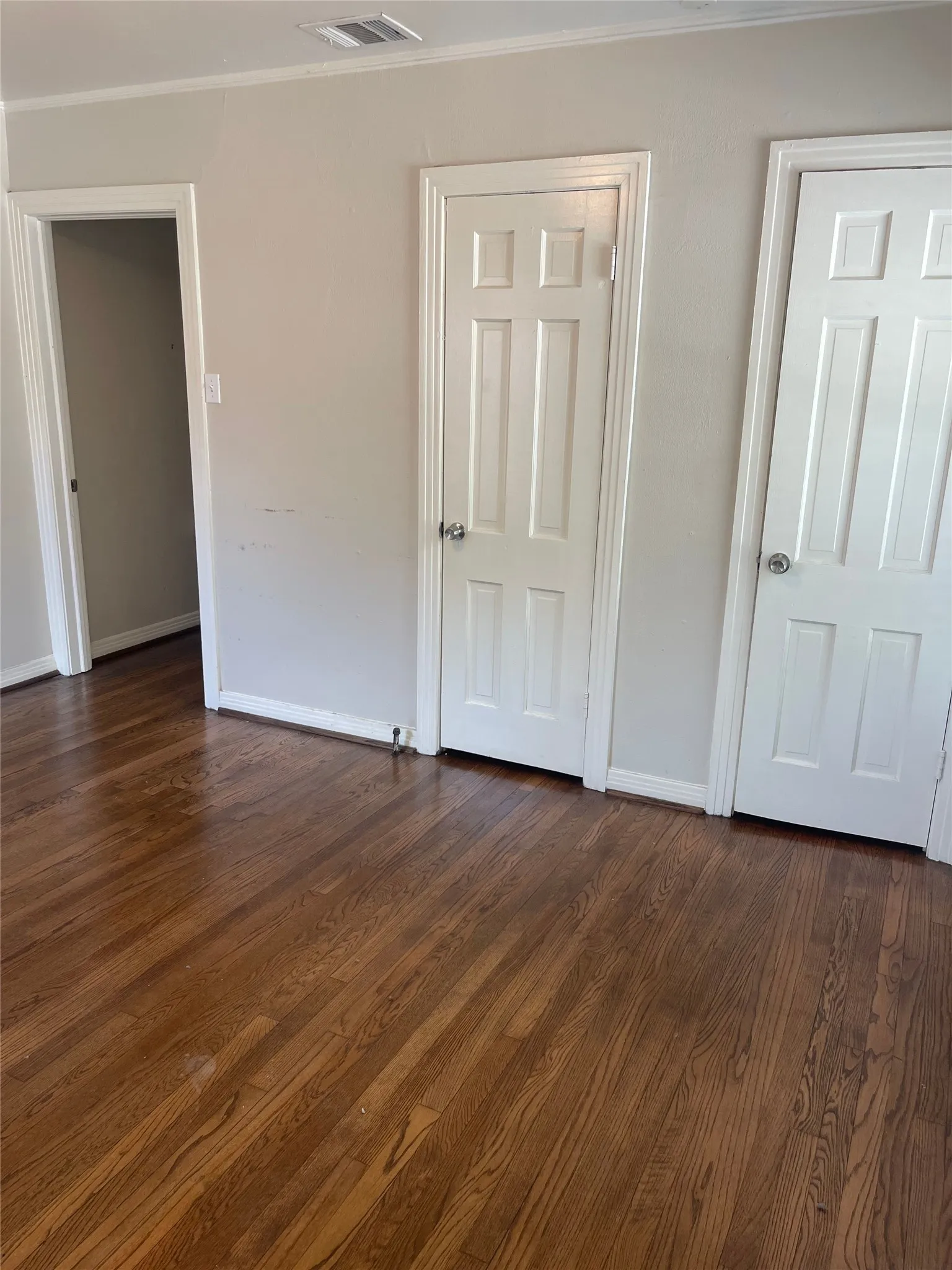 Hardwood flooring, painted interior walls, white trim, and panel doors