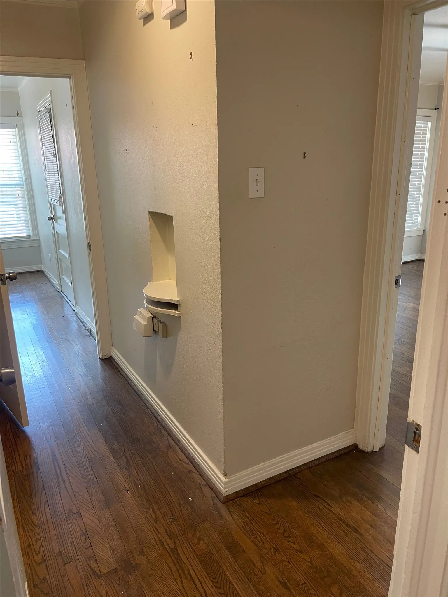 Wood-finish flooring throughout, white trim, and a built-in wall niche