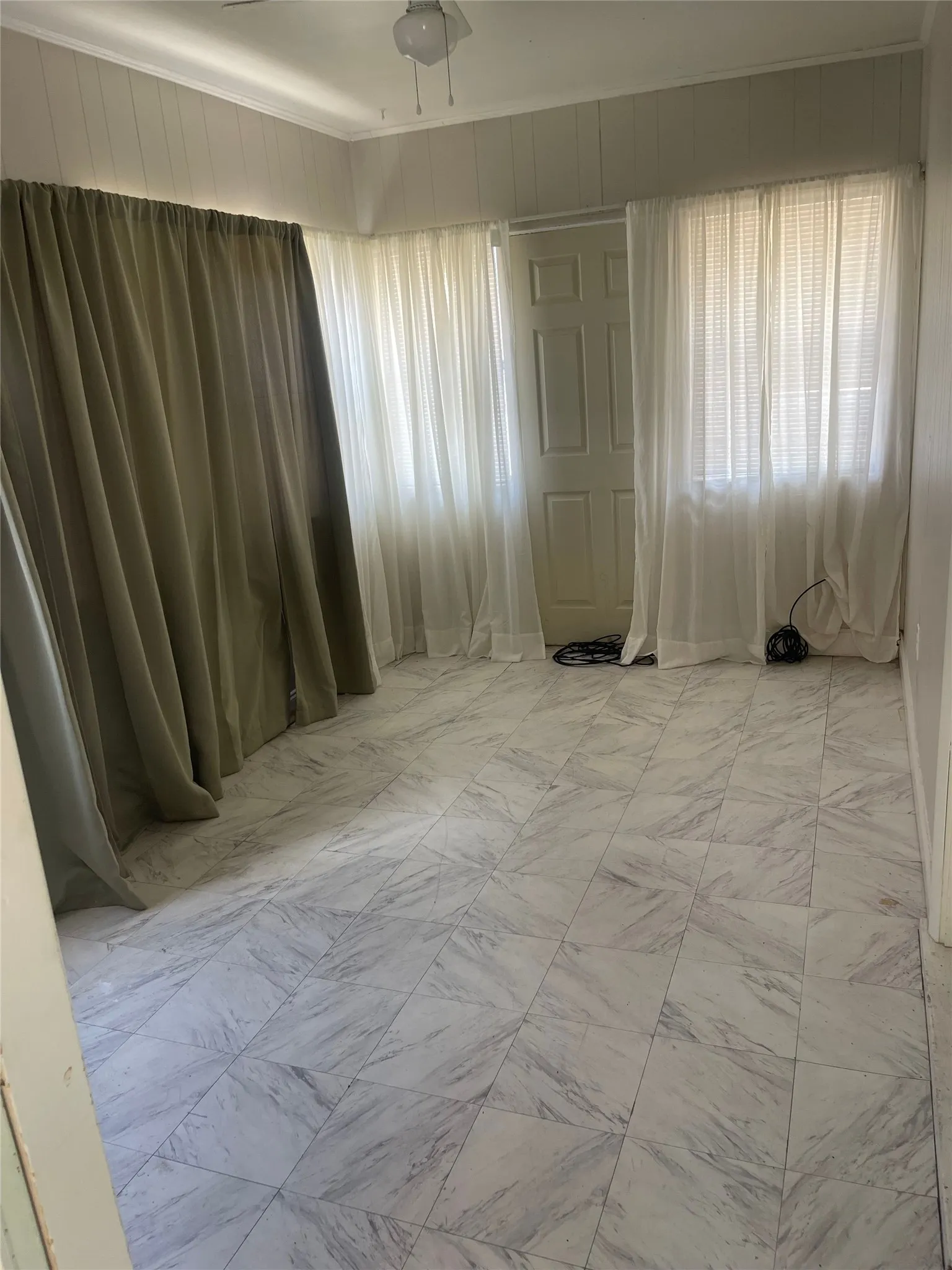 White paneled door, ceiling-mounted light fixture, and crown molding