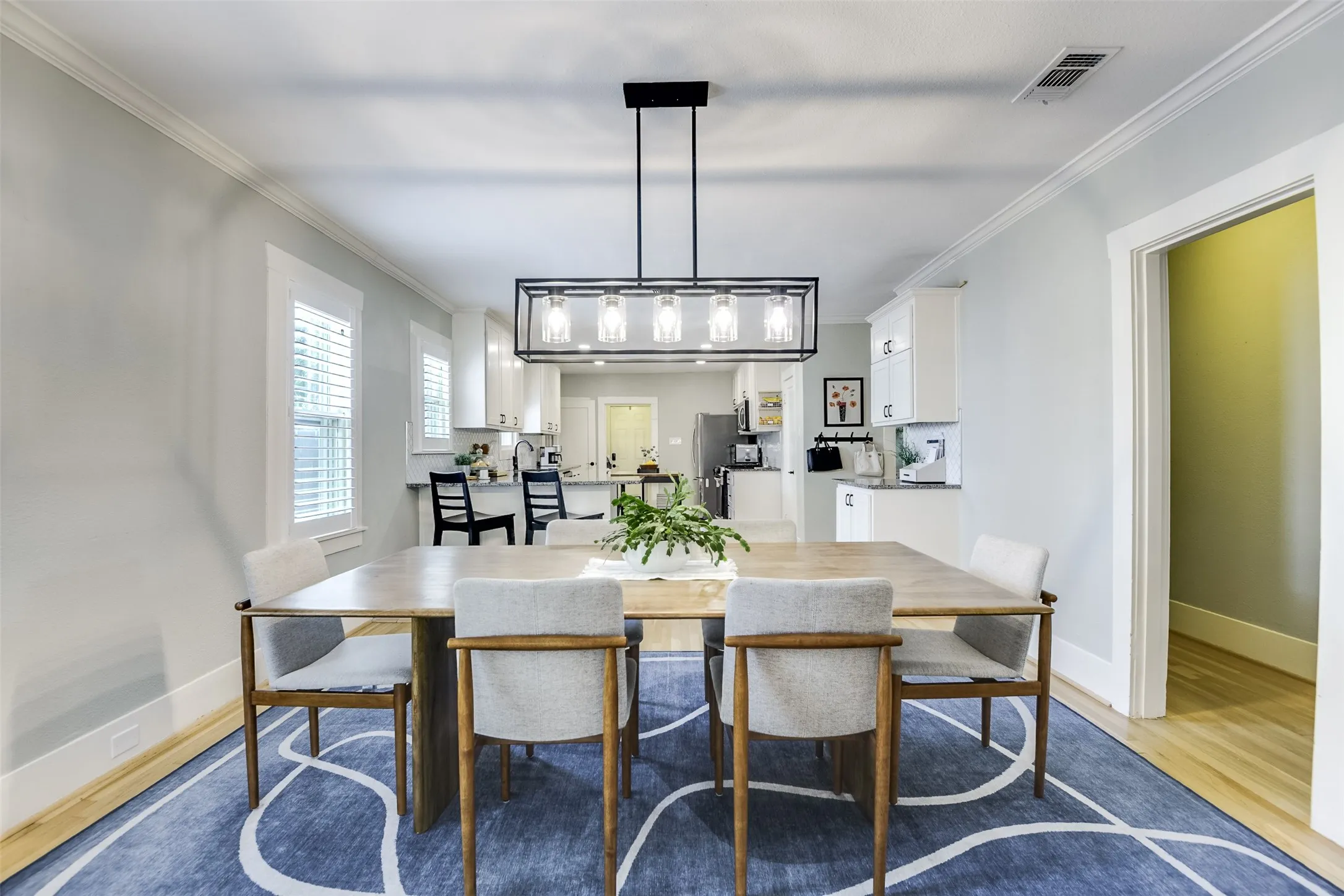 Gleaming wood floors beautifully complement this versatile, expandable dining area ready to accommodate everything from an intimate dinner to a festive holiday gathering with family and friends.