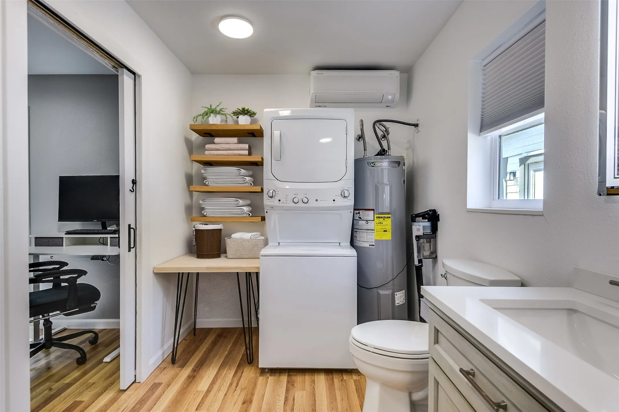 Combination utility room and bath deliver the ultimate in convivence and function.  Sliding door creates privacy and keeps the wall space open.  Please note - the washer/dryer combination does not remain with the property.