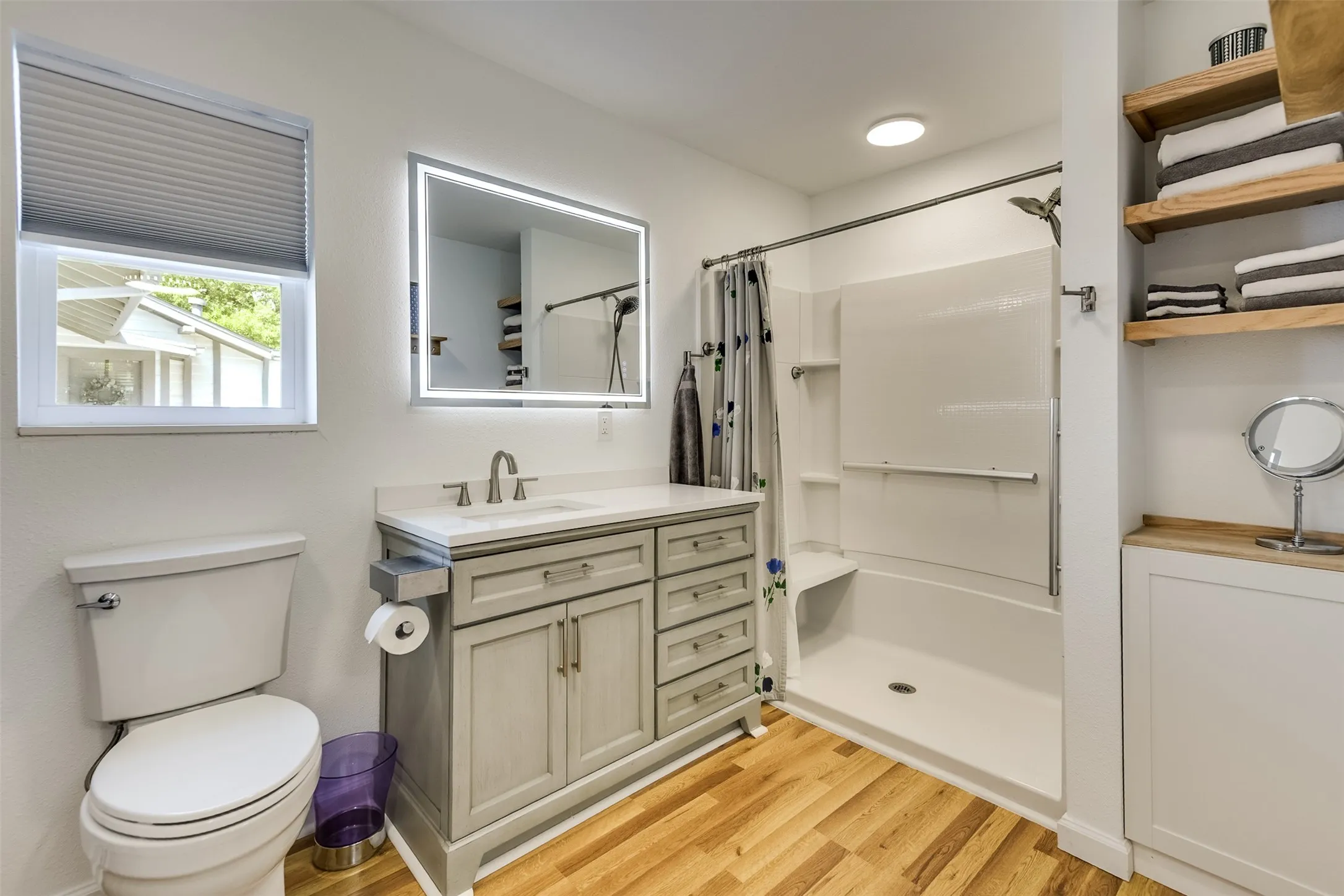 Striking bathroom delivers style and function with continuous durable flooring, a fresh vanity with excellent storage, and walk-in shower complete with bench. Additional linen storage adds everyday practicality while the backlit, anti-fog mirror similar to the primary bath adds a polished look.