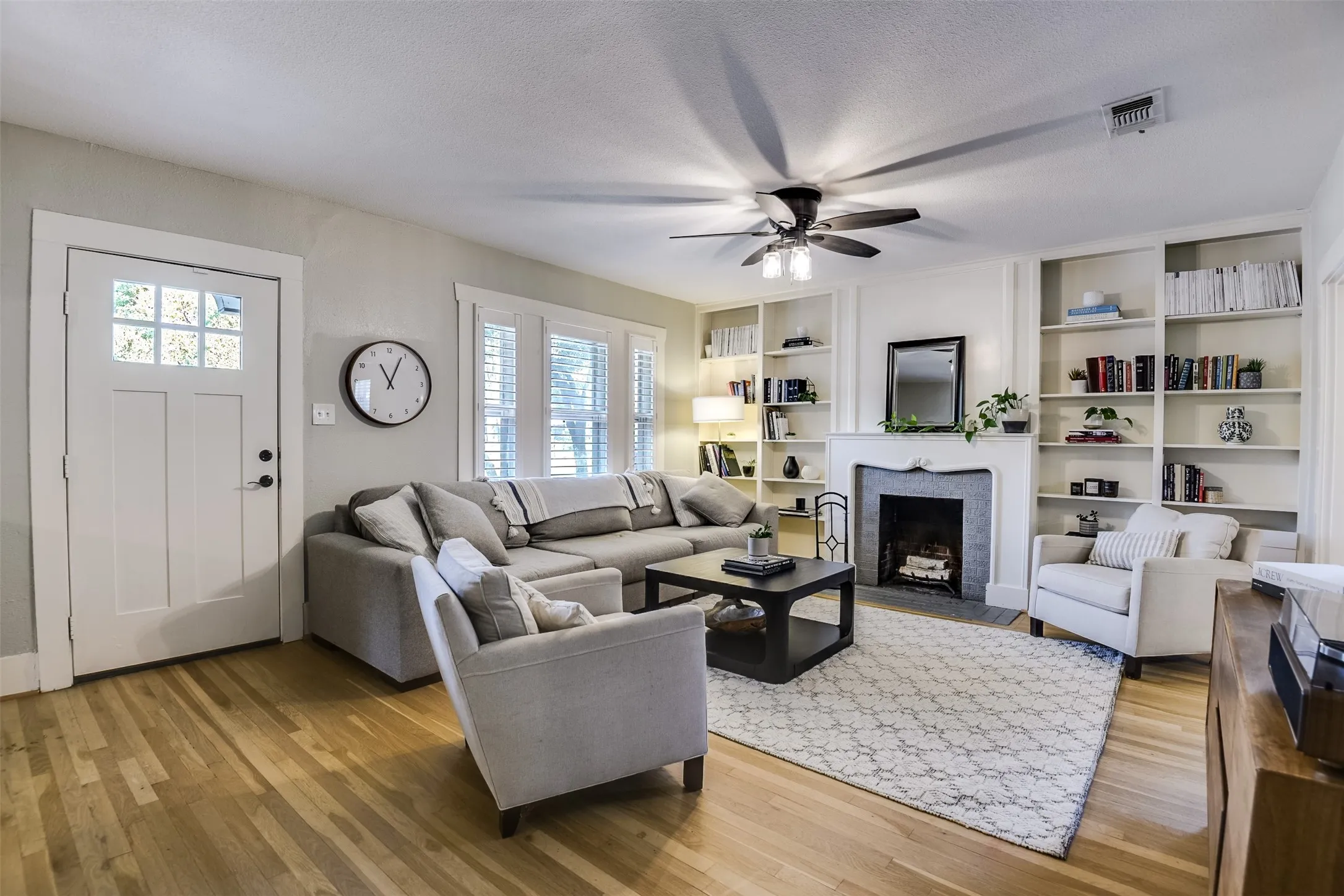 Refined, well-balanced interior features a delightful woodburning fireplace complimented with a traditional mantle flanked by dual sets of display shelves, the perfect place to display your favorite collection or diverse library.
