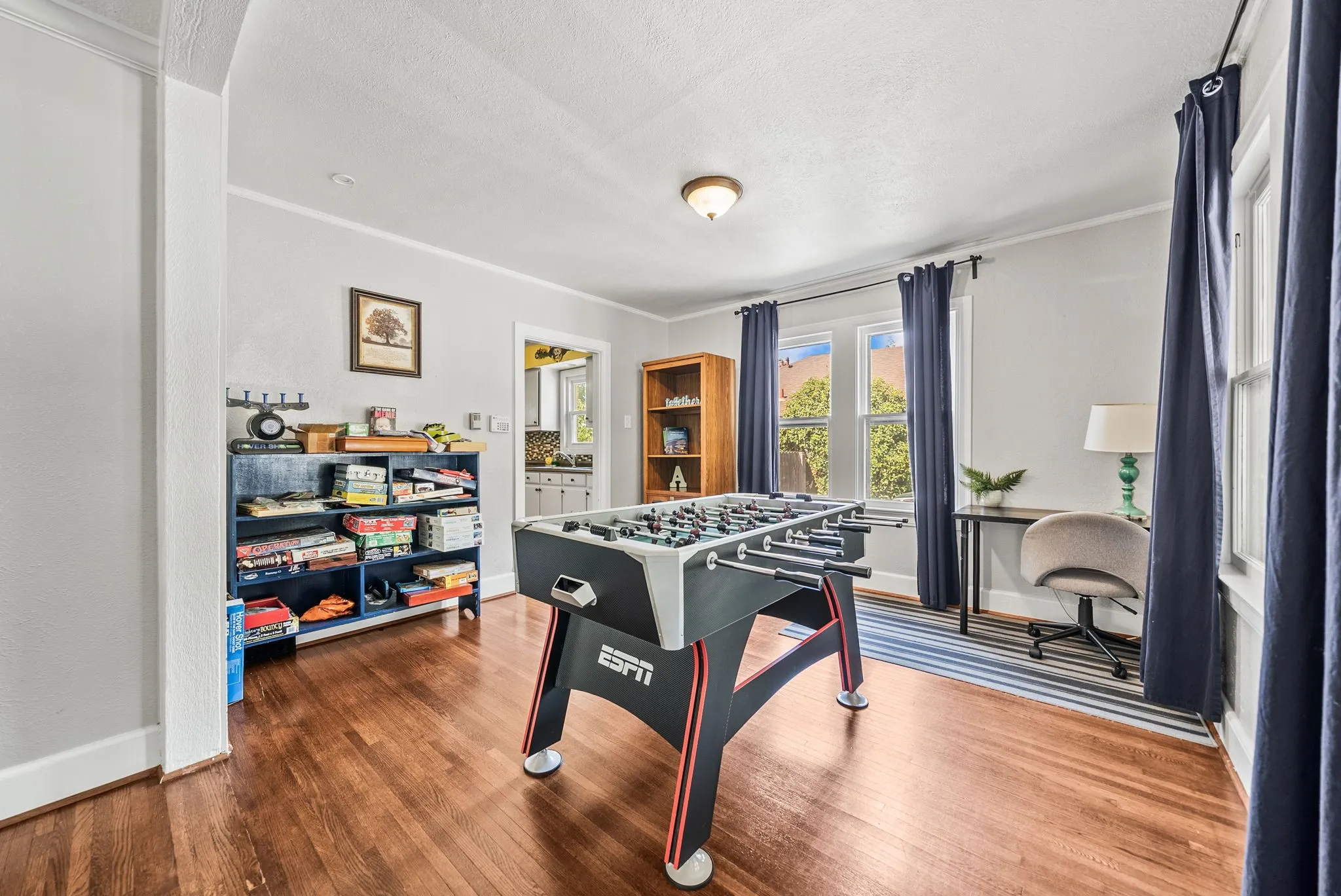 Polished wood-finish flooring, ample natural light from multiple windows, and recessed ceiling fixture