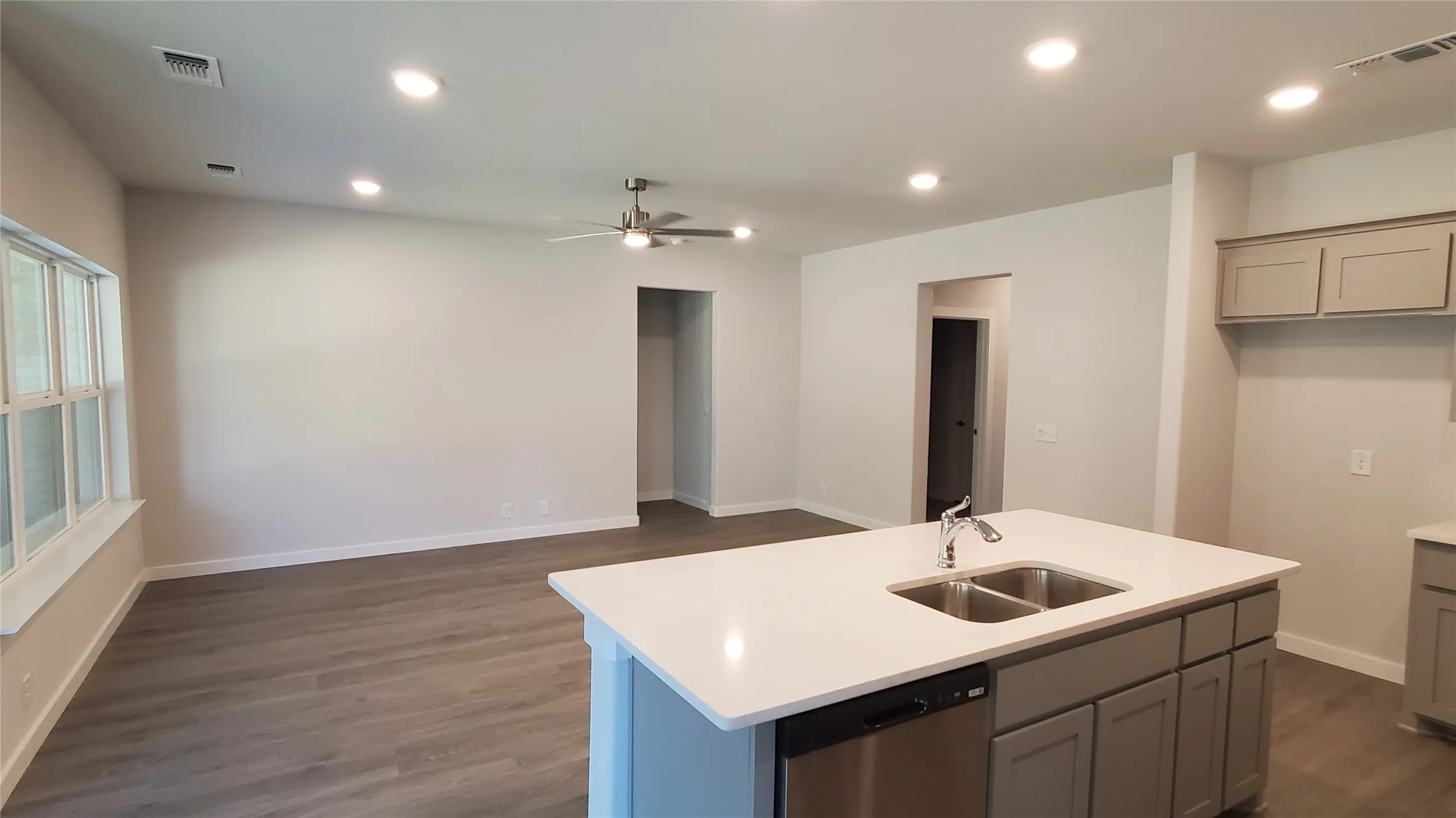 Open-concept living space featuring wood-finish flooring, recessed lighting, and a ceiling fan