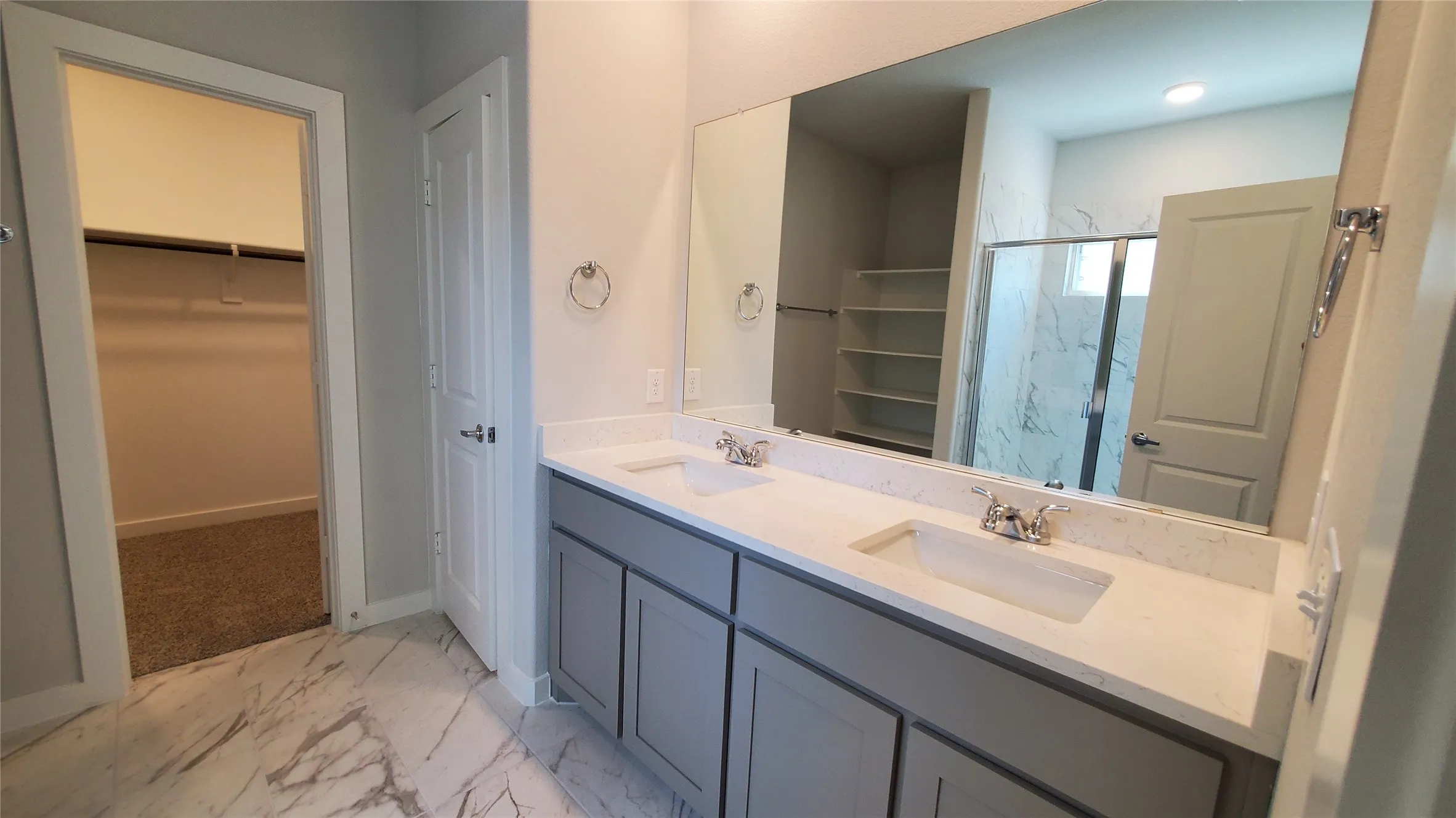 Dual vanity with undermount sinks, stone-look countertop, and chrome fixtures