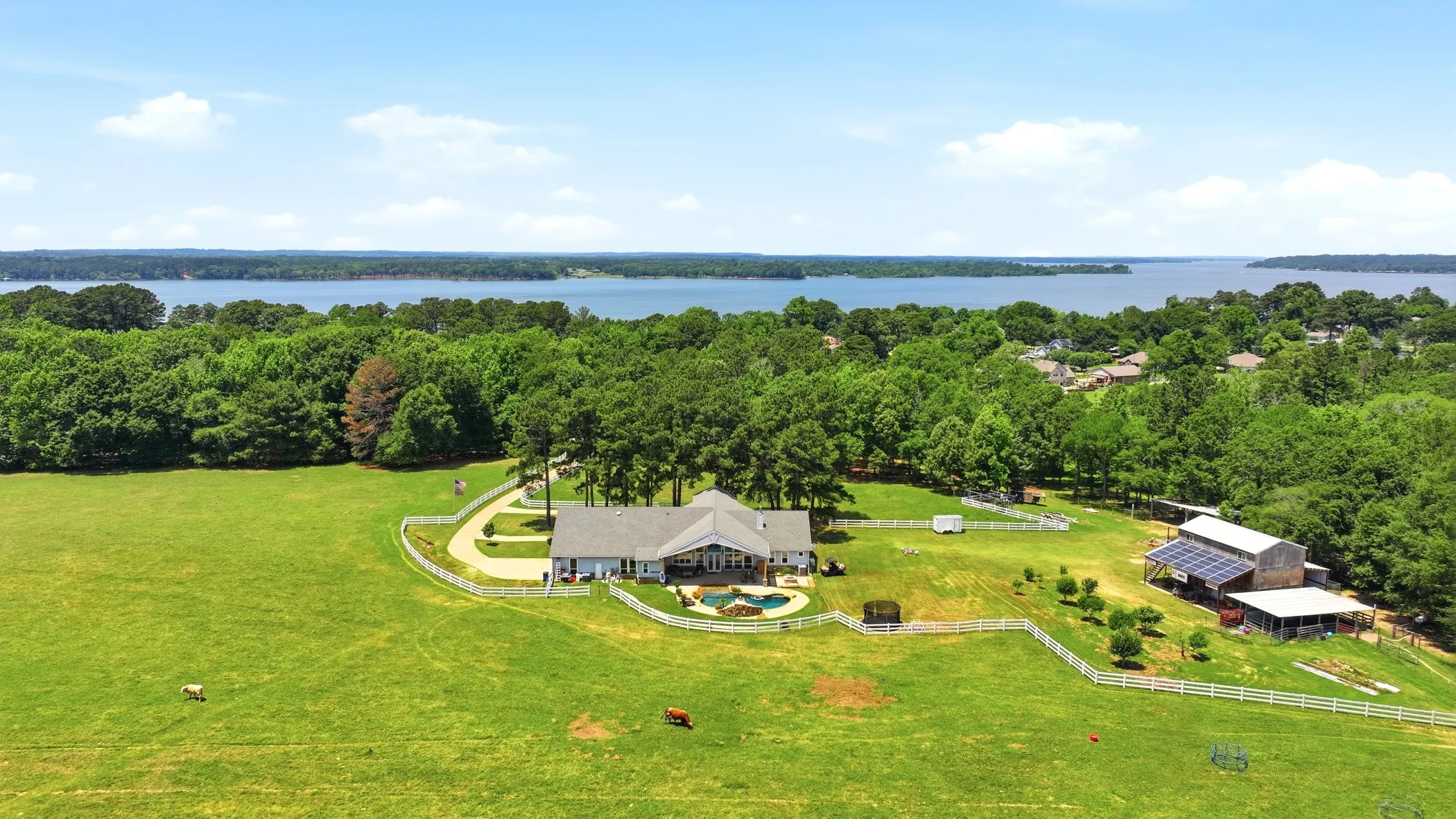 Expansive green pastures and a large body of water provide a serene backdrop to this property