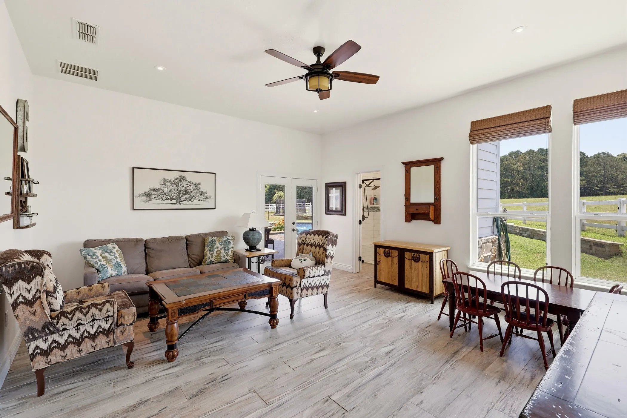 Vaulted ceilings, wood-finish flooring, recessed lighting, ceiling fan, and abundant natural light from multiple windows