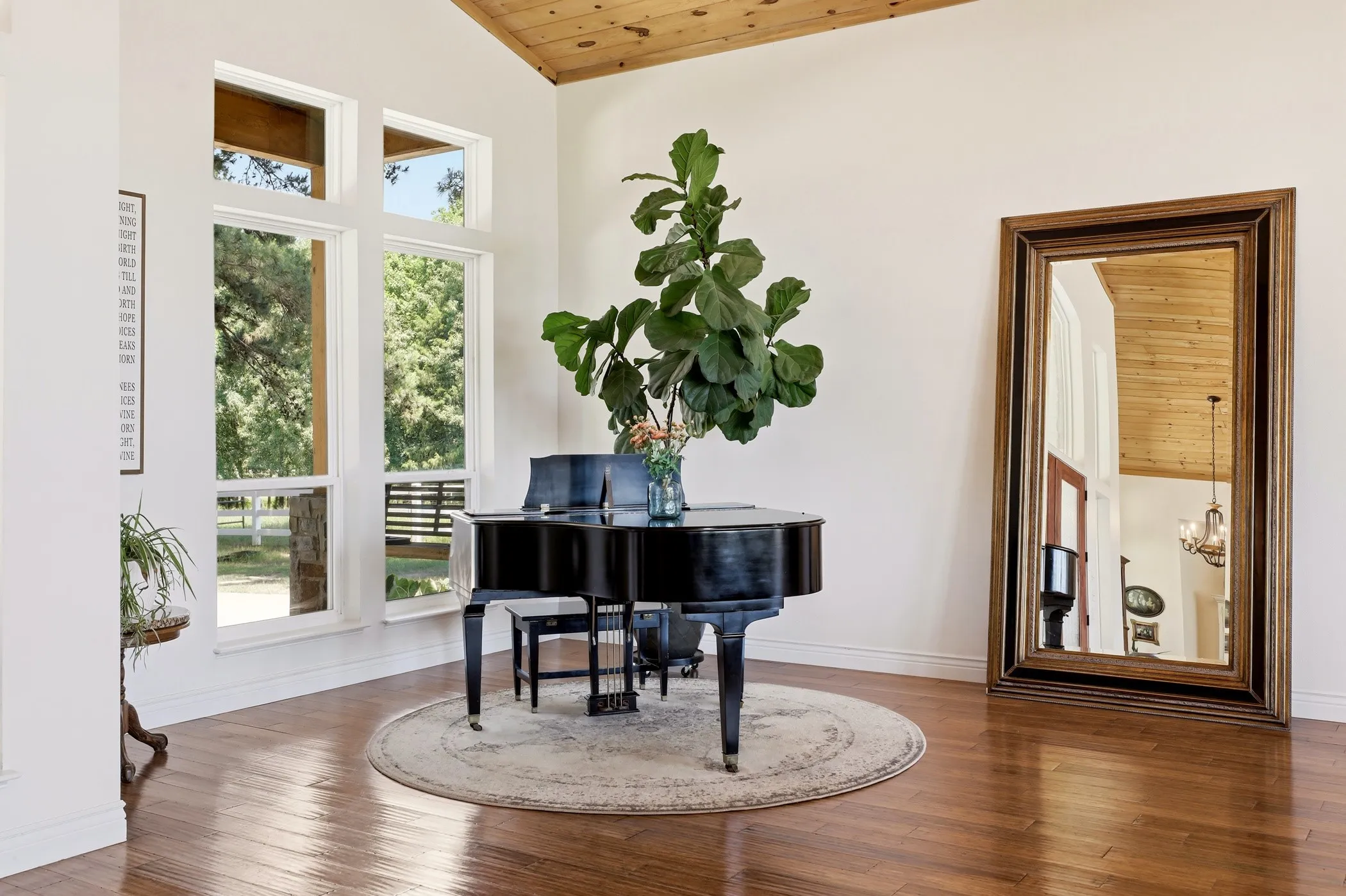 Vaulted wood-paneled ceiling, expansive windows, wood-finish flooring, and white walls