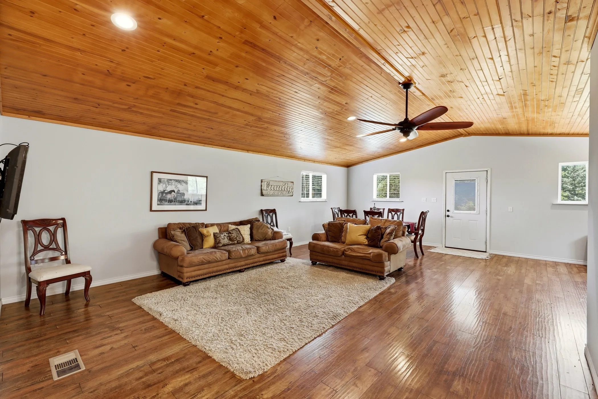 Vaulted wood-paneled ceiling with recessed lighting, wood-finish flooring, and multiple windows