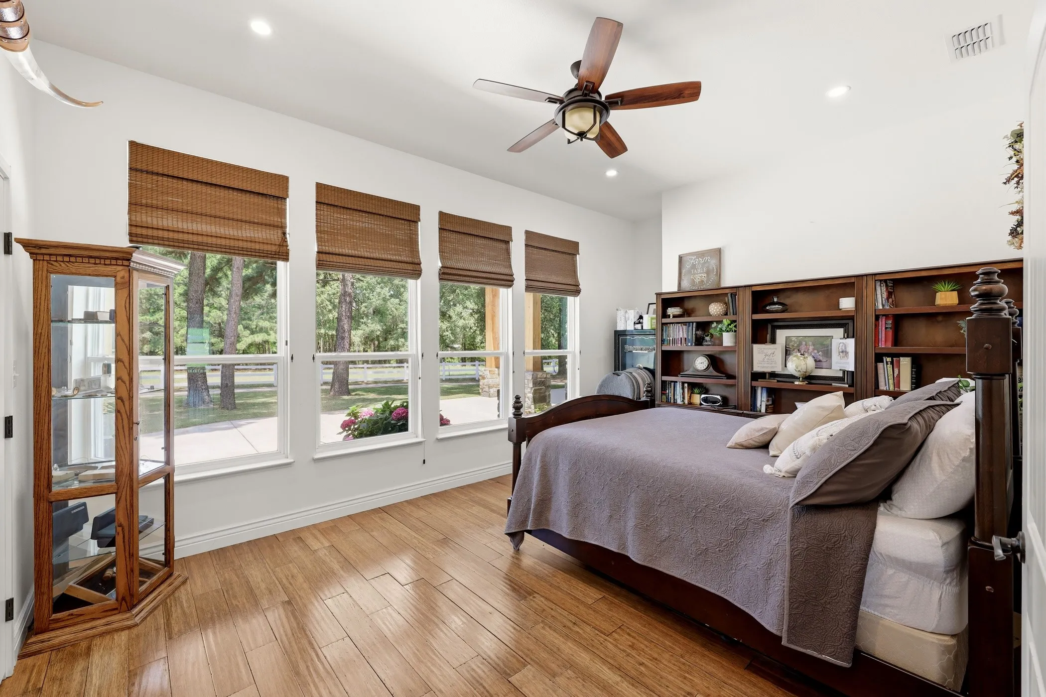 Wood-finish flooring with three windows featuring woven shades