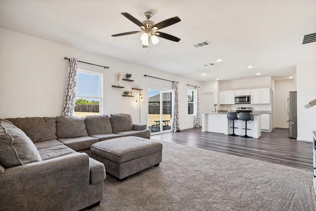 Recessed lighting, ceiling fan, wood-finish flooring, white cabinetry, and granite countertops