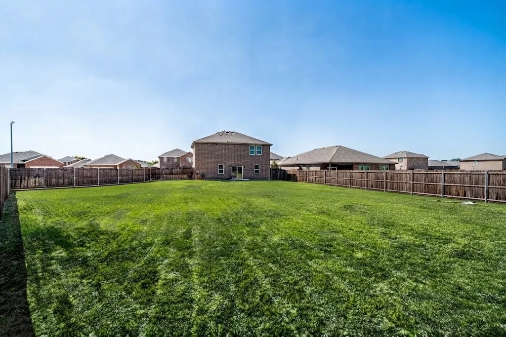 Expansive grass lawn with full wood fencing