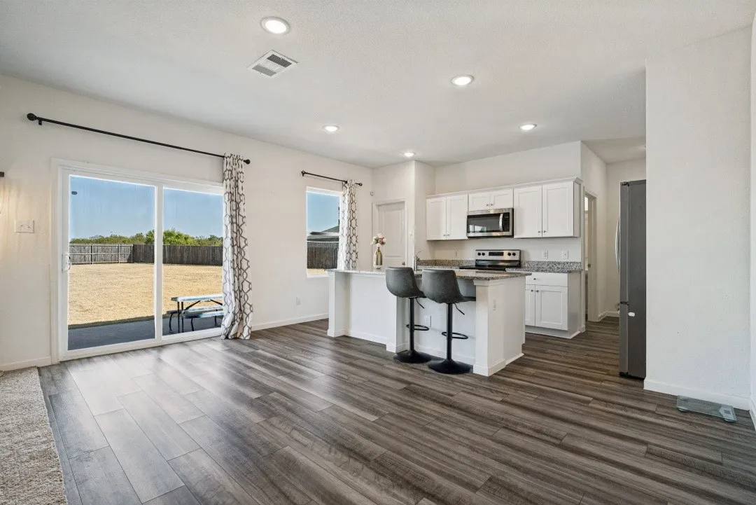 Open-concept living area featuring wood-finish flooring and recessed lighting