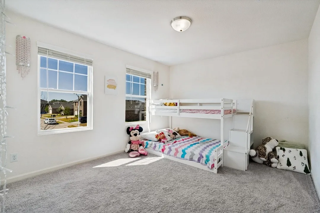 Neutral wall color, two double-hung windows, flush mount ceiling light, and wall-mounted light fixtures