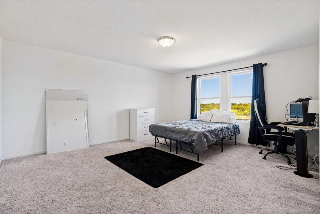 Carpeted room with white walls, dual windows, and a flush-mount ceiling light fixture