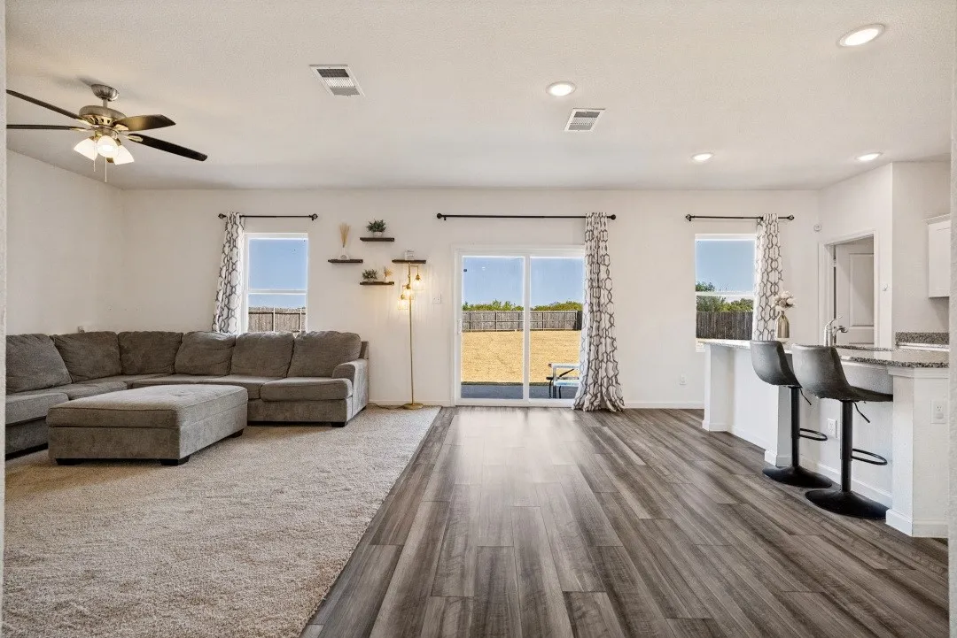 Open-concept living space featuring wood-finish flooring, recessed ceiling lighting, and a ceiling fan