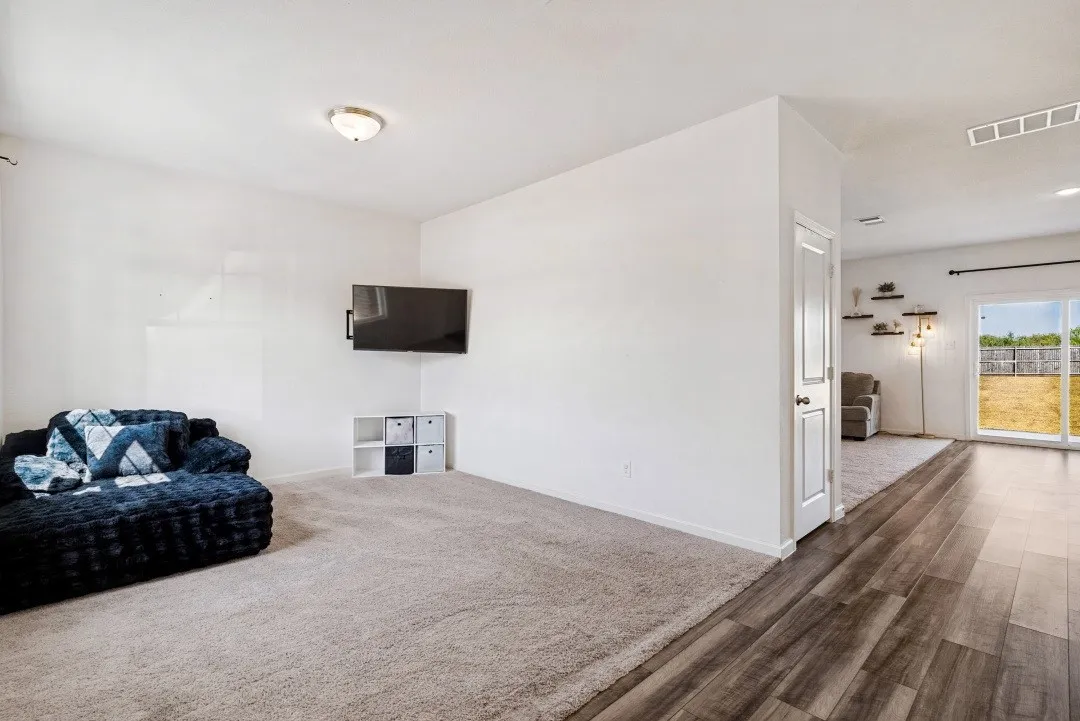 Carpeted living area with a flush-mount ceiling light