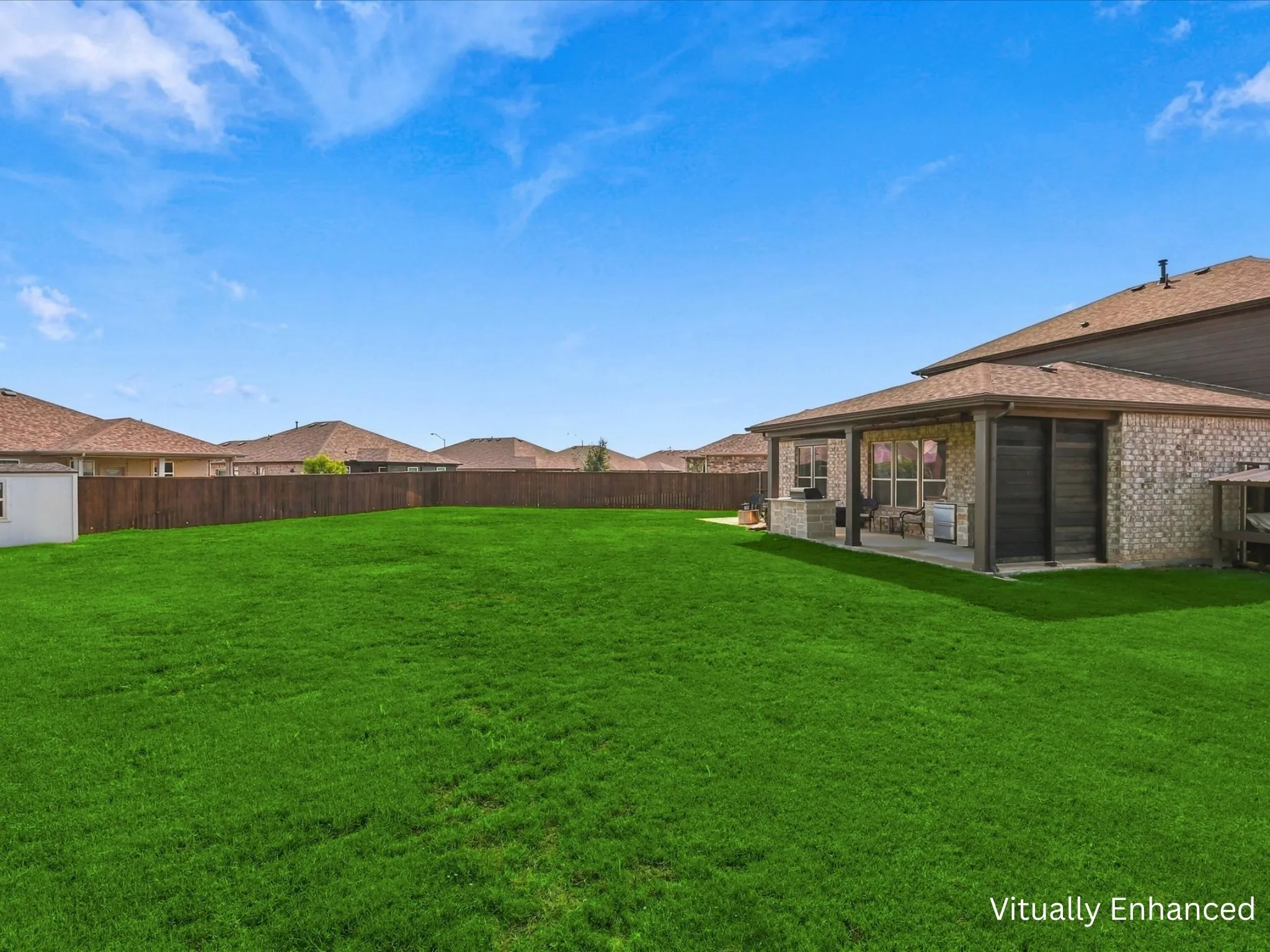 Oversized backyard showing back patio entertaining area and storage building.