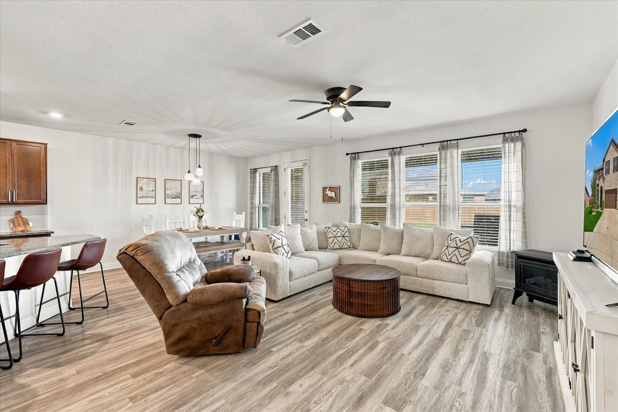 Large open area with dining room, living room, and kitchen with oversized island which provides a lot of additional seating