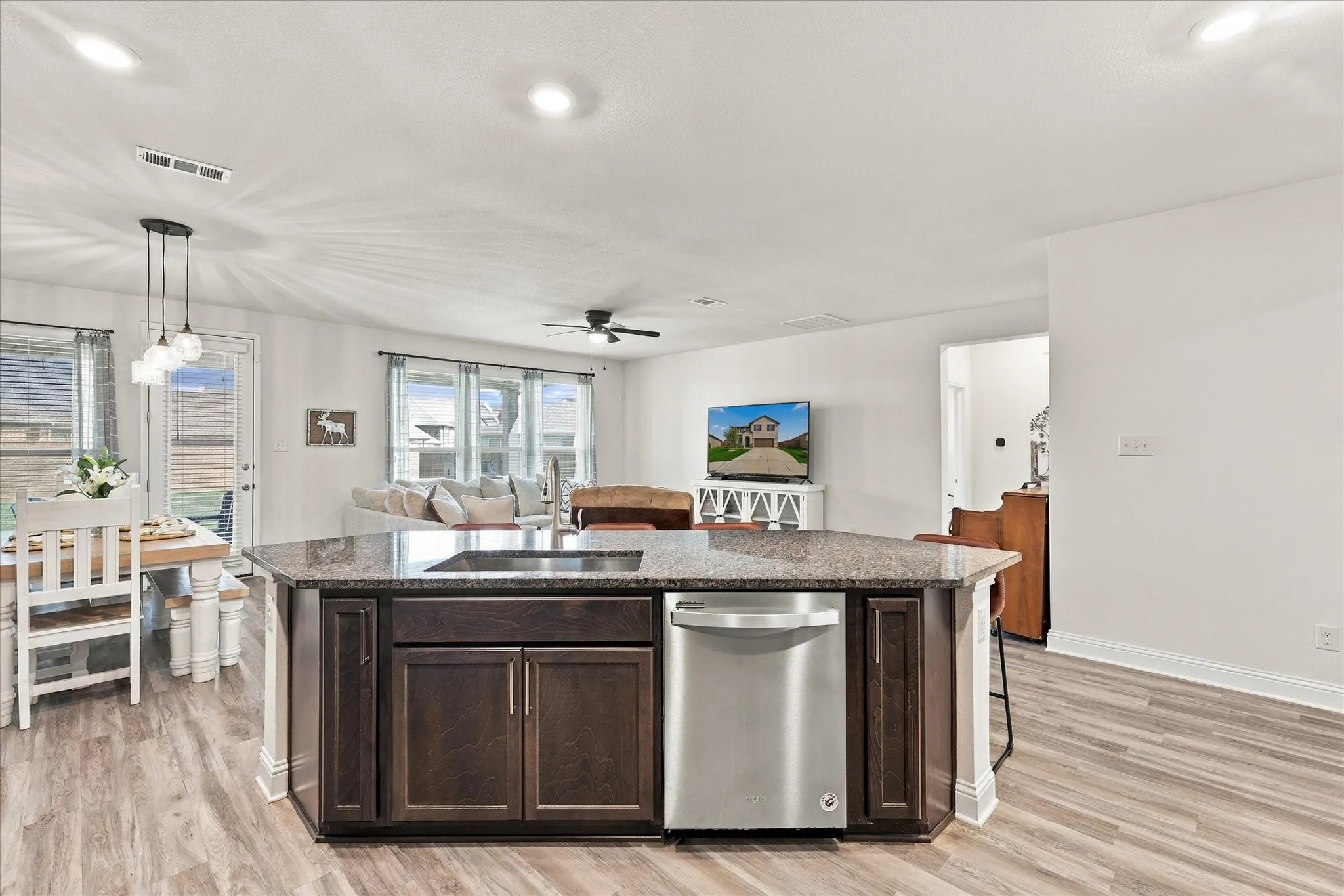Large open area with dining room, living room, and kitchen with oversized island which provides a lot of additional seating