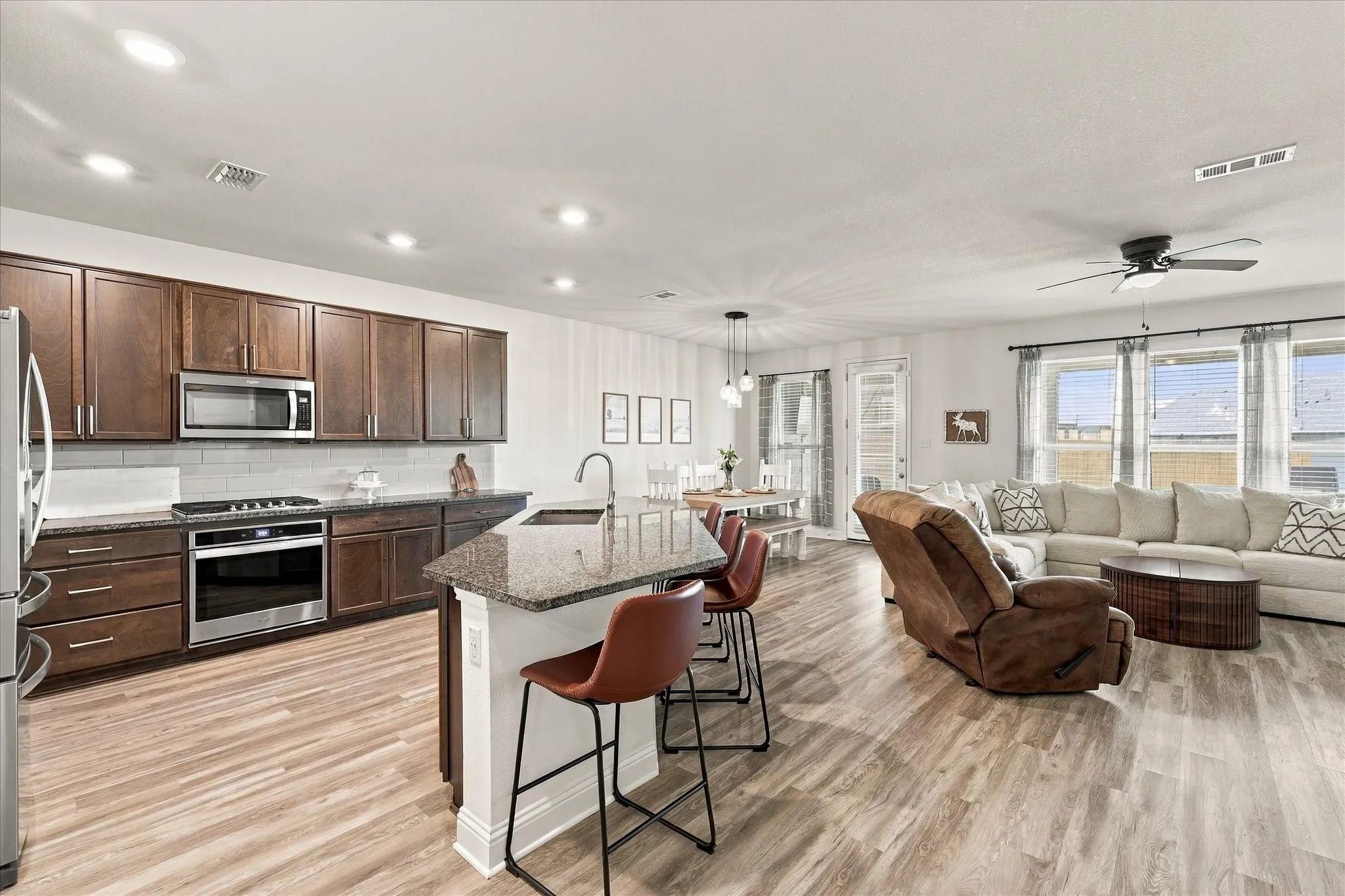 Large open area with dining room, living room, and kitchen with oversized island which provides a lot of additional seating