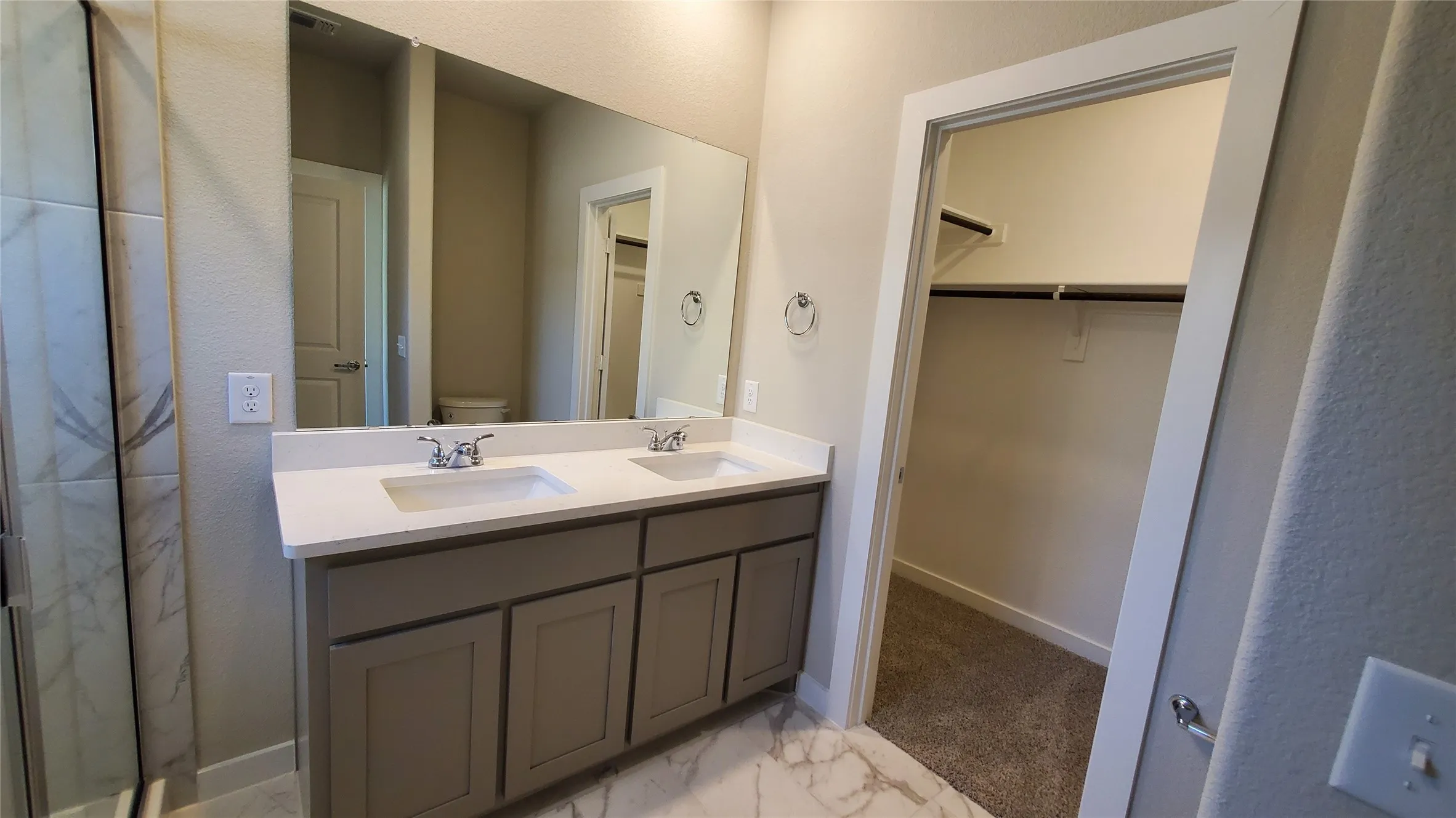 Double vanity with integrated sinks, white countertop, and gray cabinetry