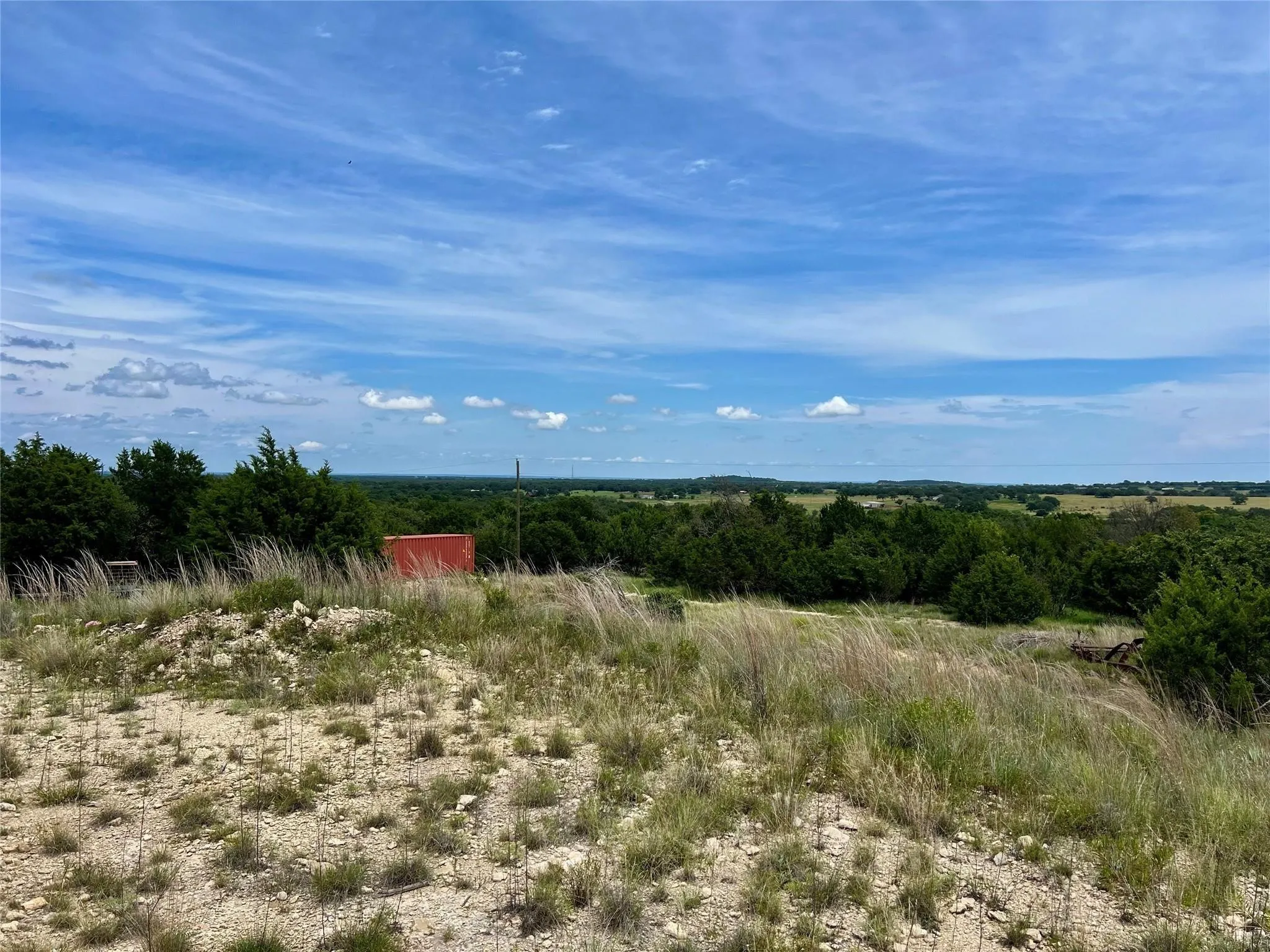 Expansive undeveloped land featuring mature trees and distant landscape