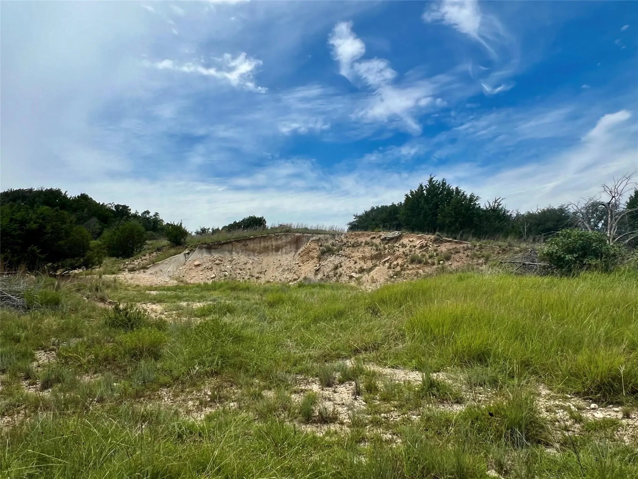 Expansive undeveloped land with varied topography, featuring natural vegetation and mature trees
