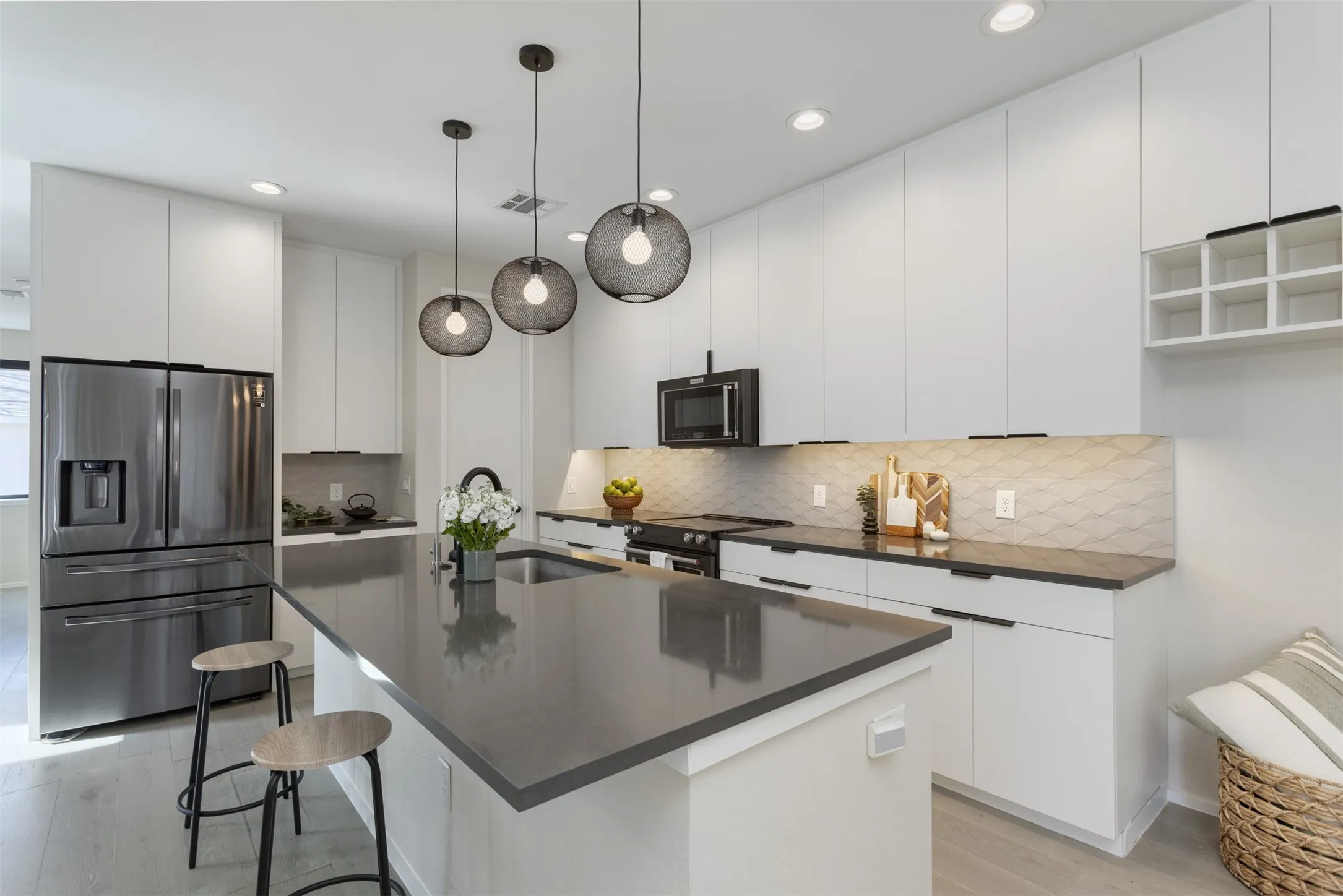 Kitchen with stainless steel fridge, a kitchen bar, white cabinets, modern cabinets, and electric range