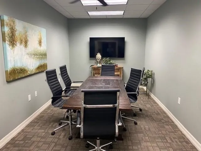 Home office with a paneled ceiling and dark colored carpet