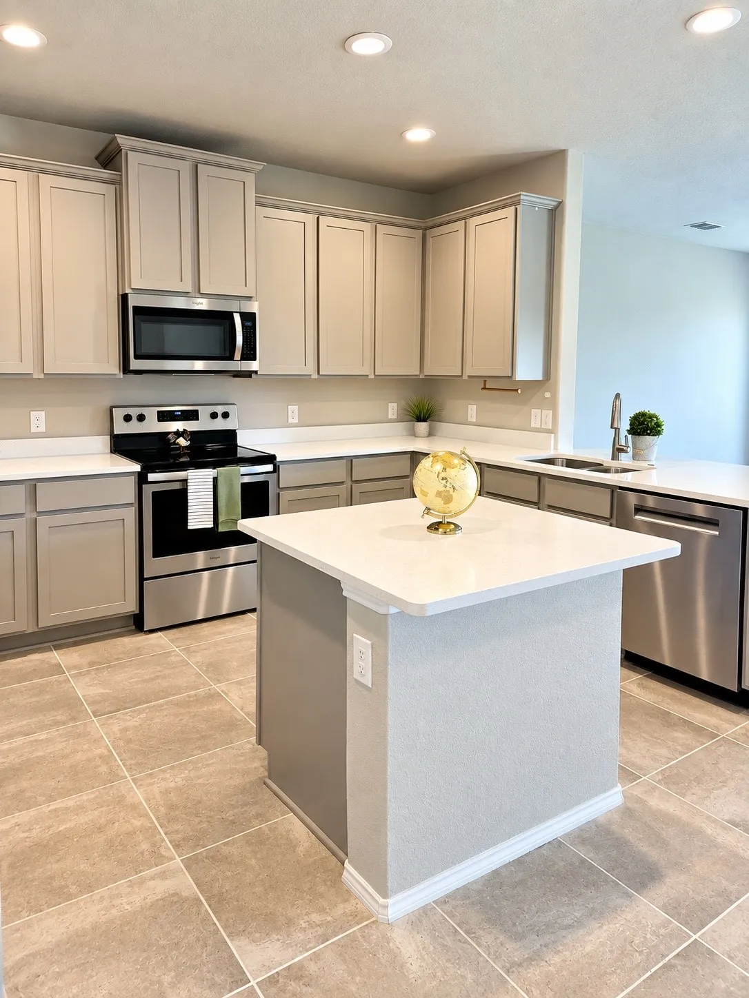 Kitchen featuring an island with white countertop, recessed lighting, stainless steel appliances, and tiled flooring