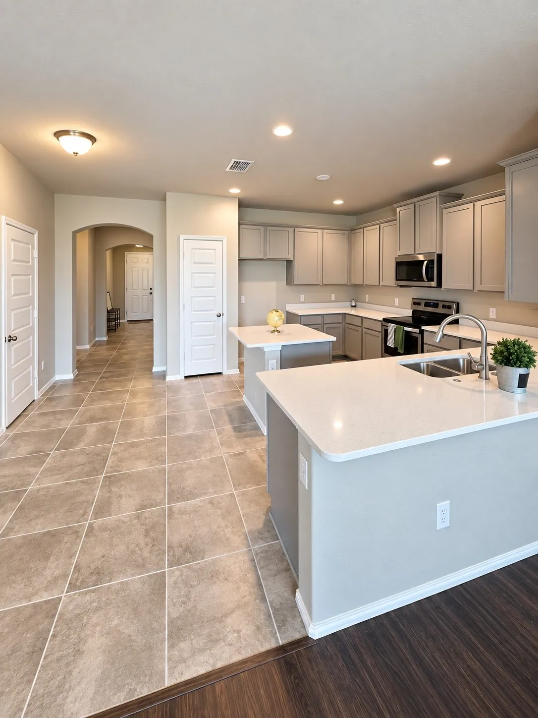 Kitchen featuring dual islands with light-toned countertops, stainless steel appliances, abundant cabinetry, and recessed lighting