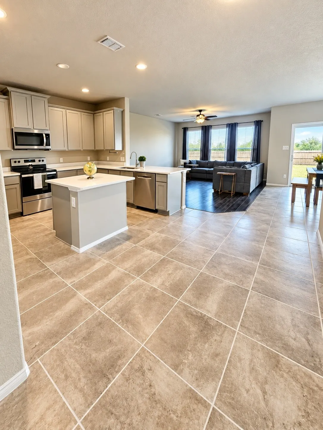 Open-concept layout featuring a kitchen island, stainless steel appliances, recessed lighting, and tile flooring