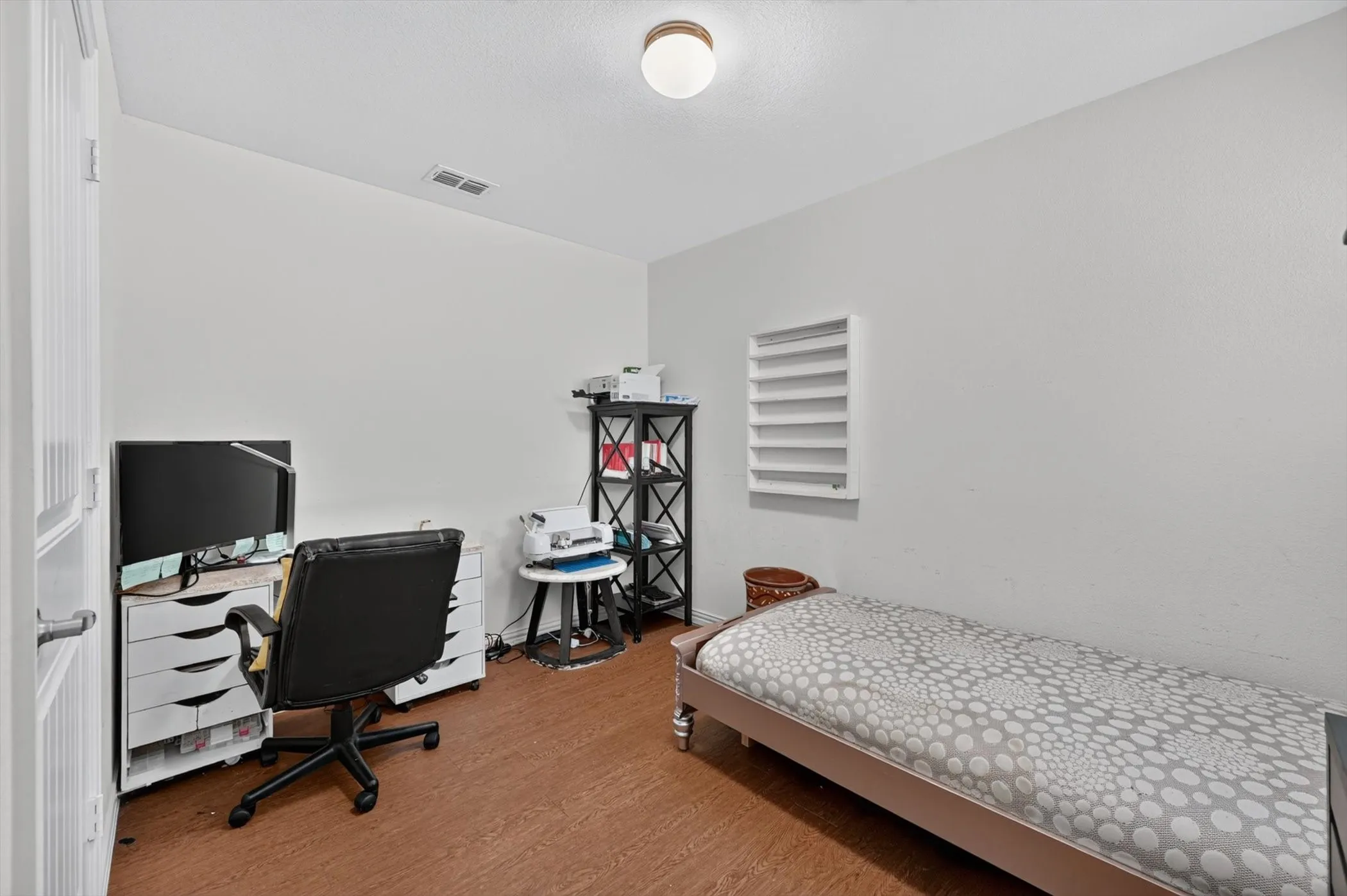 Recessed ceiling light fixture, wood-finish flooring, white walls