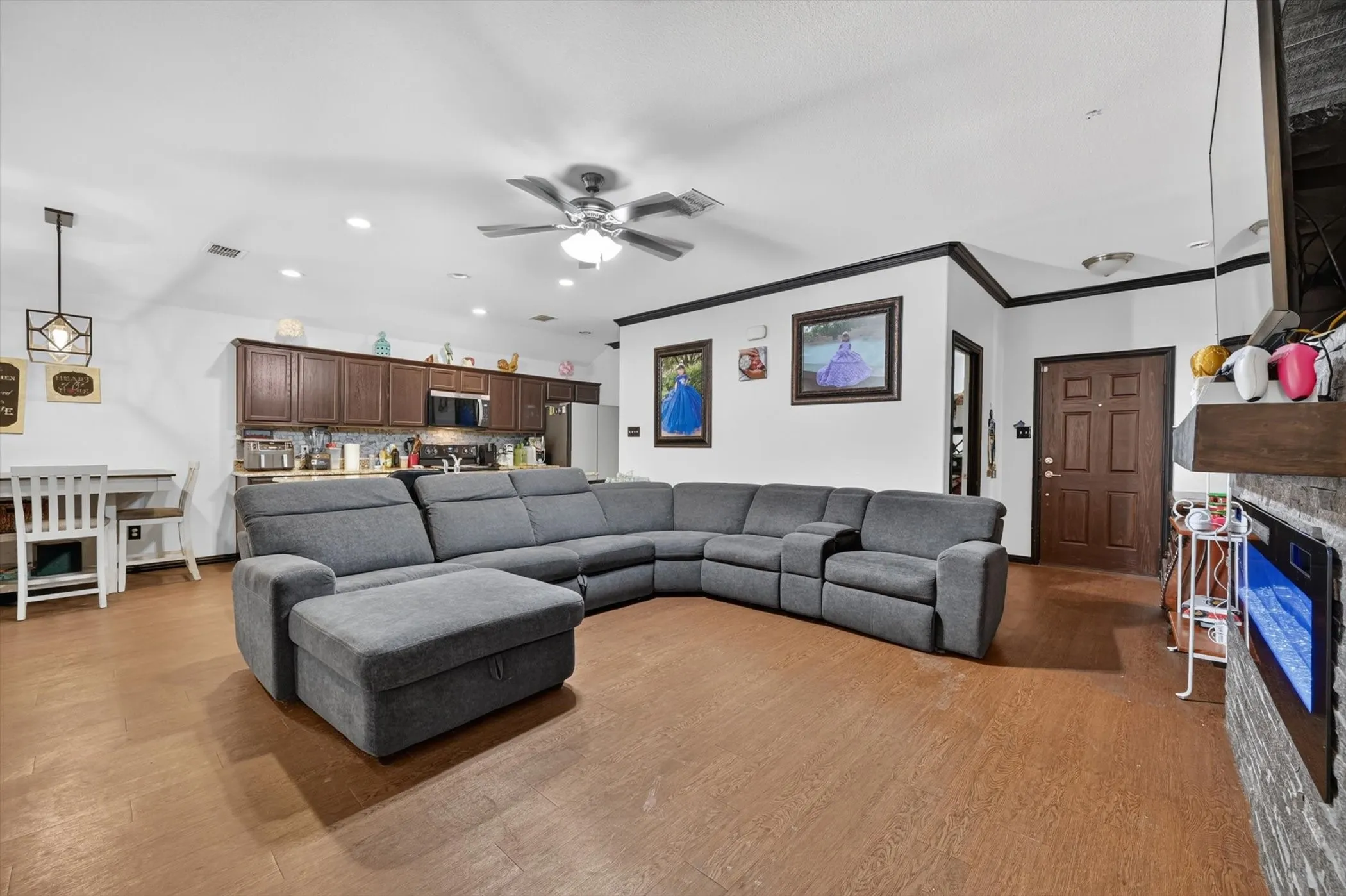 Open-concept living space featuring wood-finish flooring, recessed lighting, and a ceiling fan
