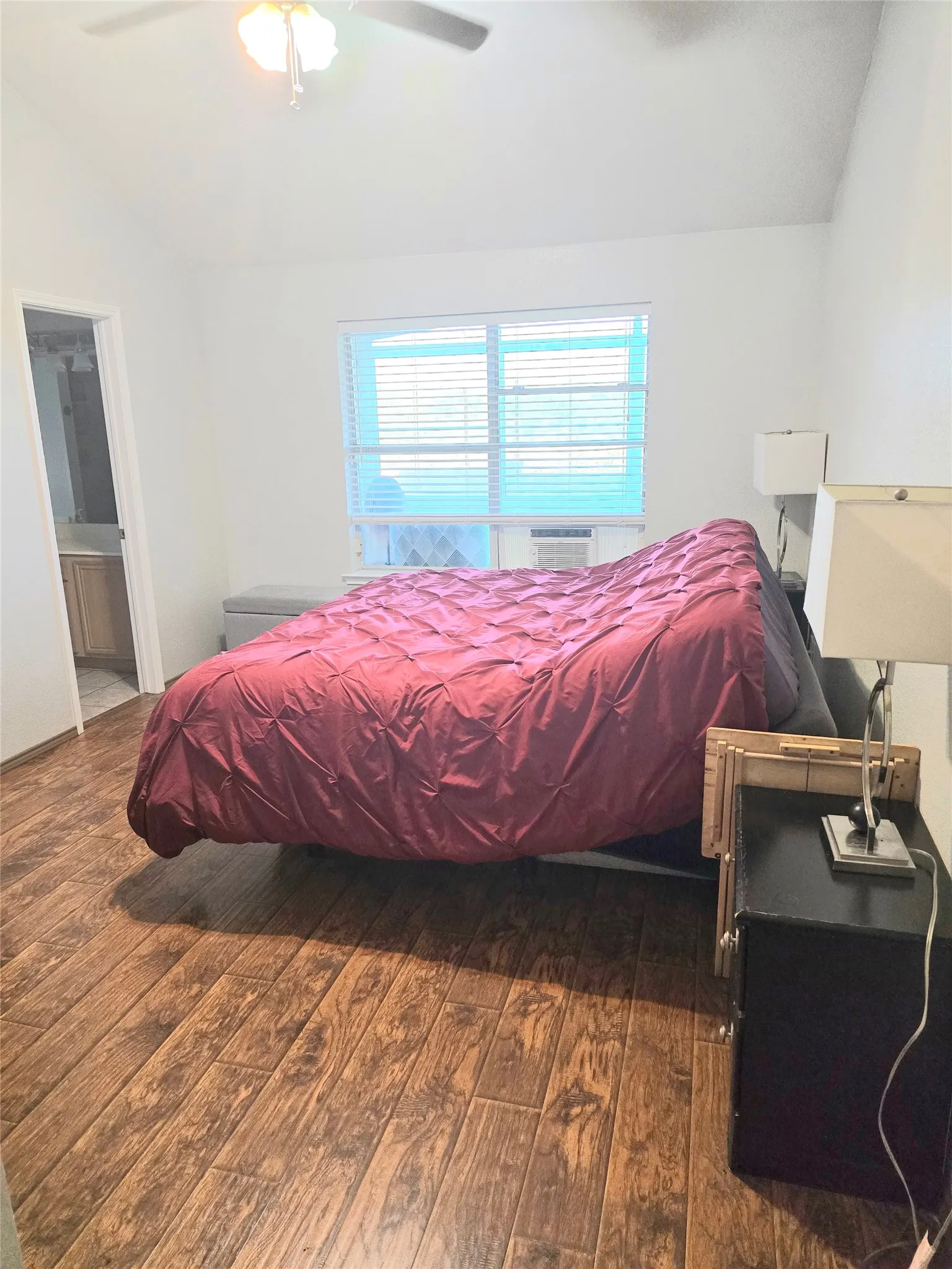 Wood-finish flooring, ceiling fan, and window with horizontal blinds