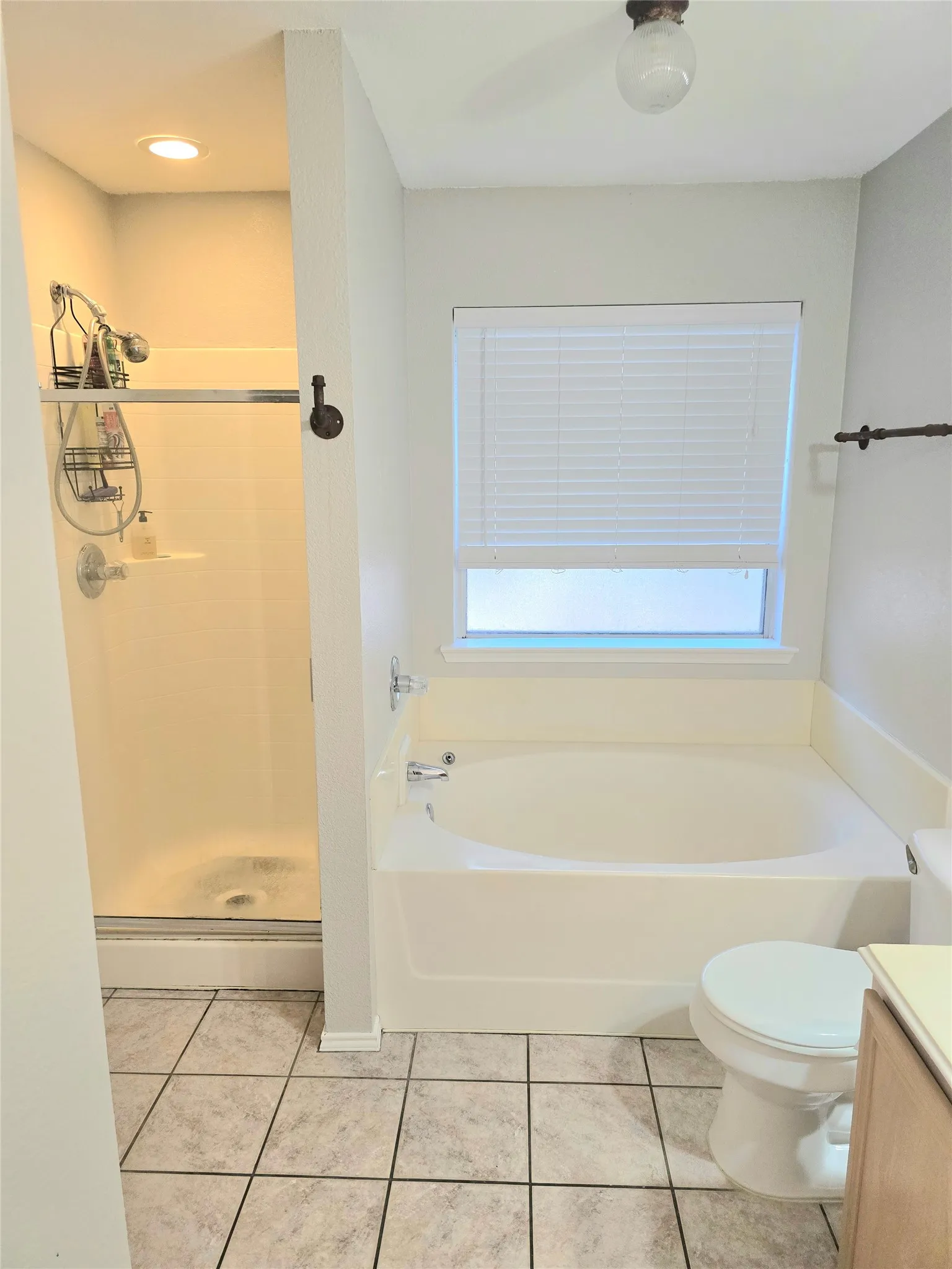 Shower with glass enclosure, recessed lighting, built-in bathtub, and ceramic tile flooring