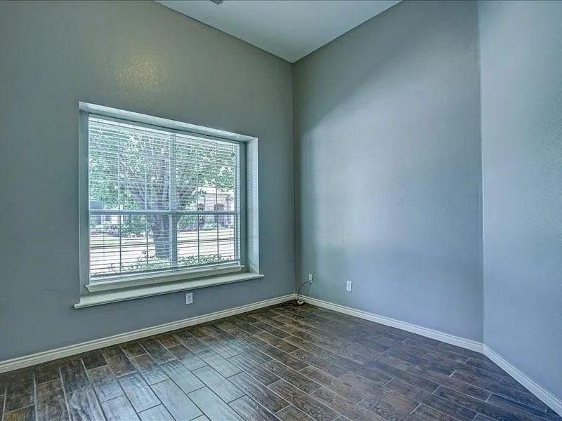 Window with blinds, tile flooring, and light blue wall finish