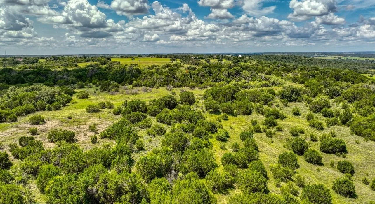 Expansive land offering diverse topography with mature trees and open grassy areas