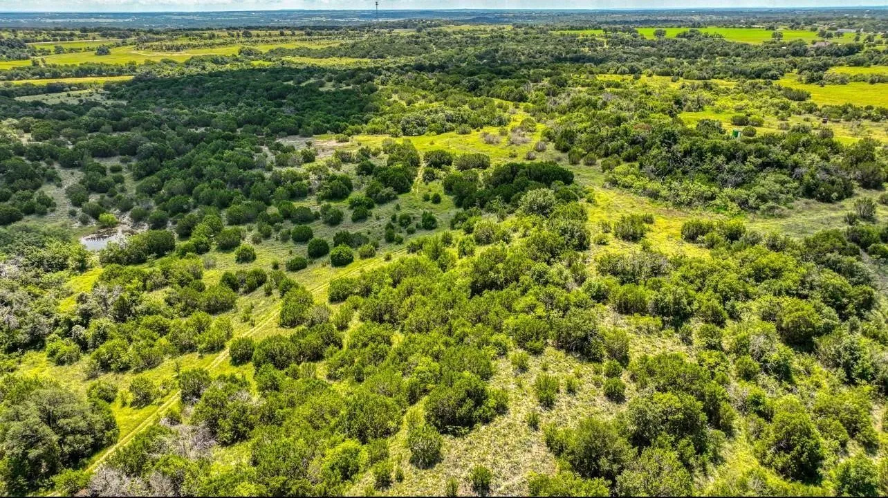 Expansive acreage featuring diverse tree coverage, open grassland areas, and varied topography