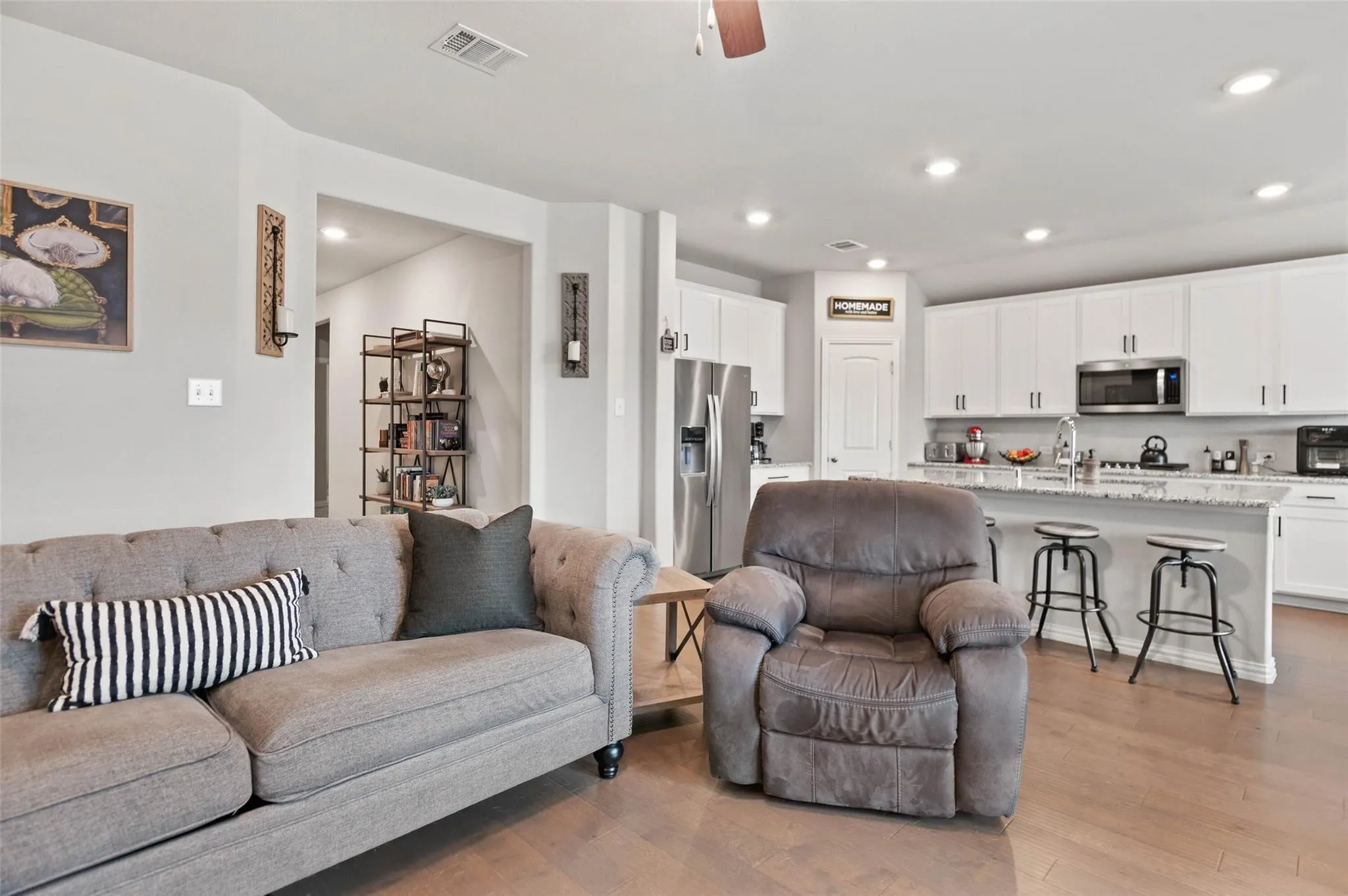 Open-concept living space with wood-finish flooring, recessed lighting, and a ceiling fan