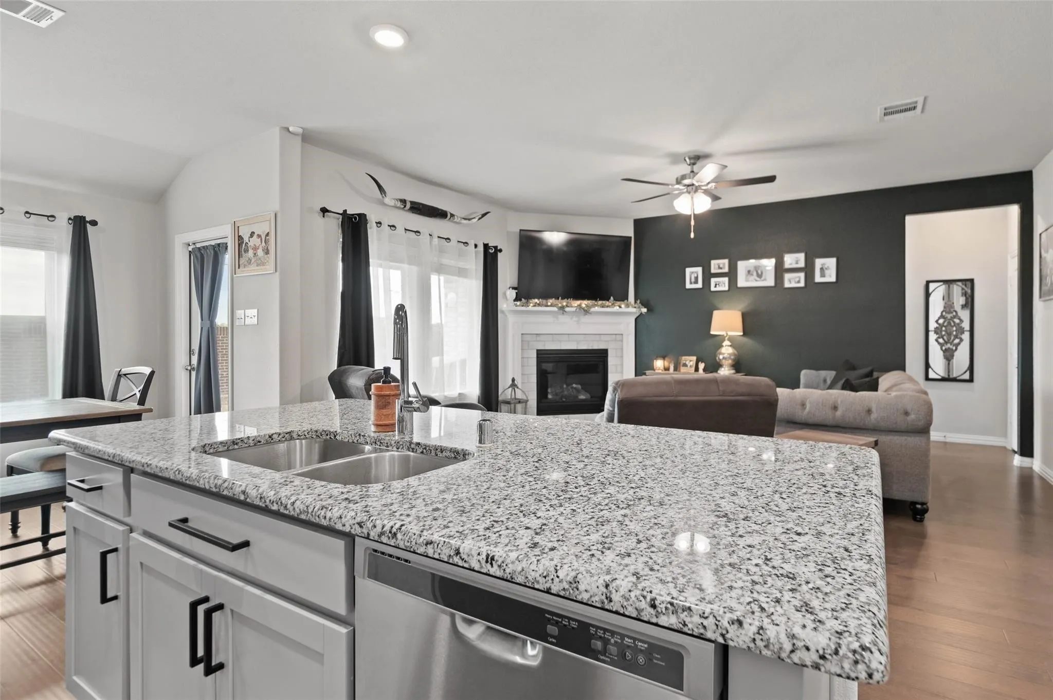 Kitchen island featuring a dual stainless steel sink and granite countertops