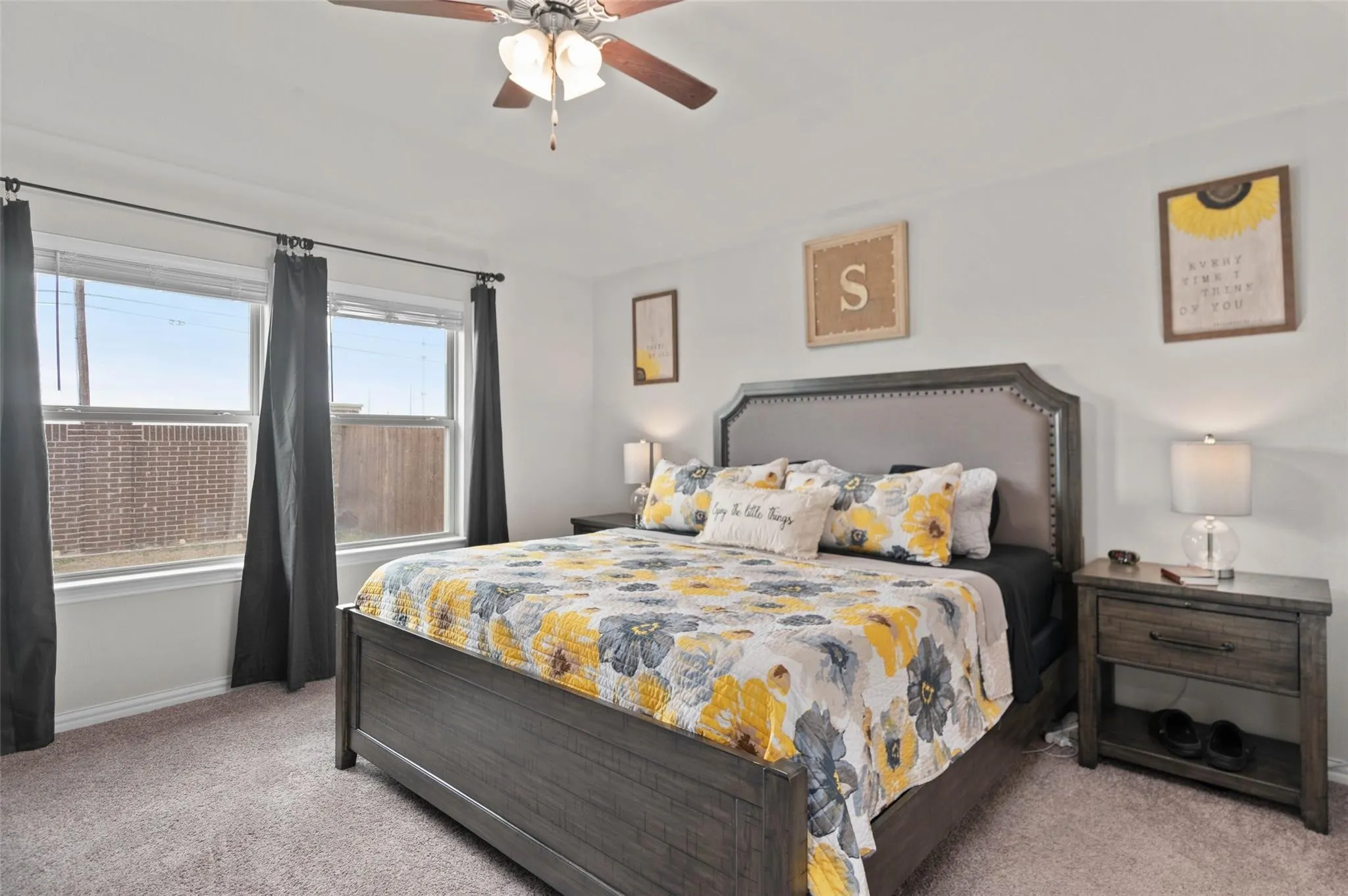 Carpeted flooring, ceiling fan with integrated lighting, multiple windows, and light-toned walls