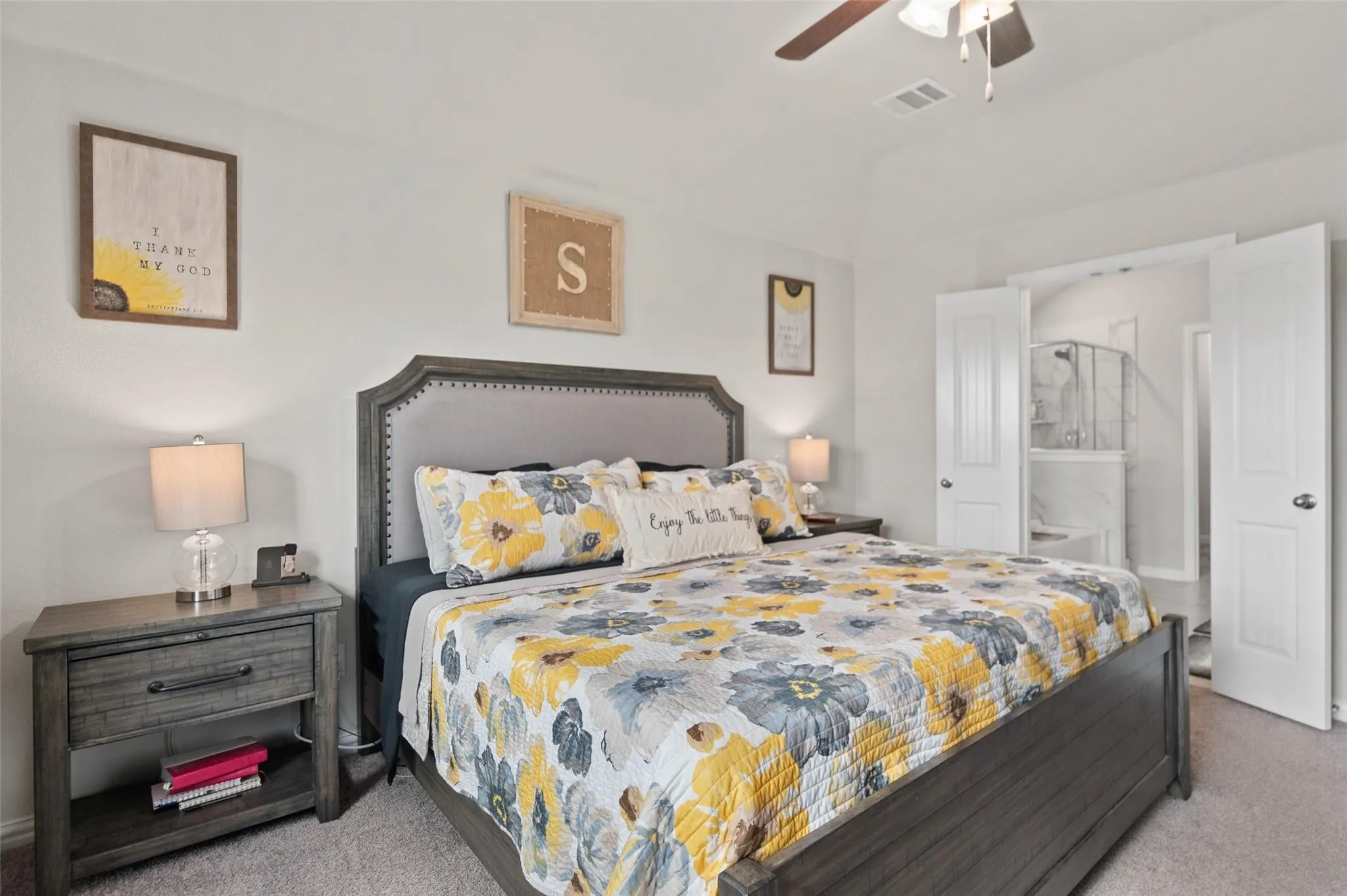 Carpeted flooring, ceiling fan, white paneled doors, and a bathroom with a glass-enclosed shower