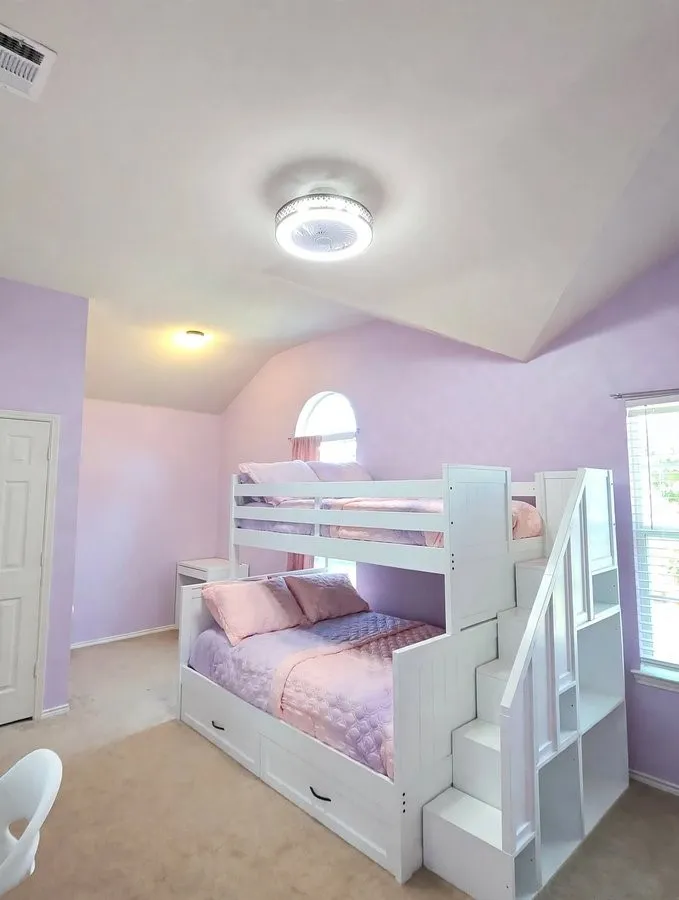 Vaulted ceiling with a flush-mount light fixture, arched window, and a white built-in bunk bed with integrated storage