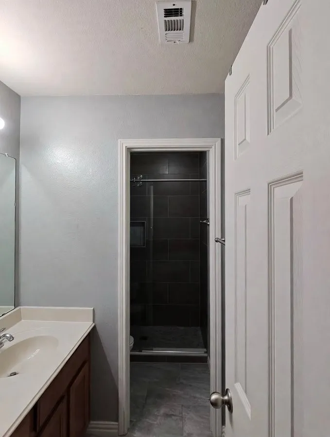 Vanity with integrated sink, panel door, and tile flooring