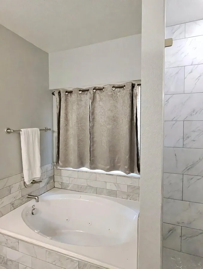 Built-in soaking tub with deck-mounted faucet, surrounded by subway tile